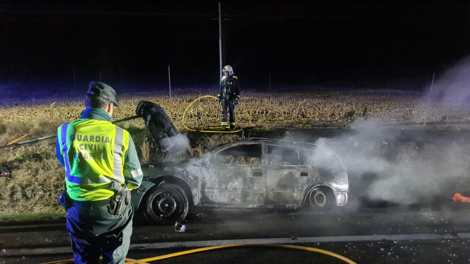 Un agente de la Guardia Civil, junto al vehículo quemado en la NA132