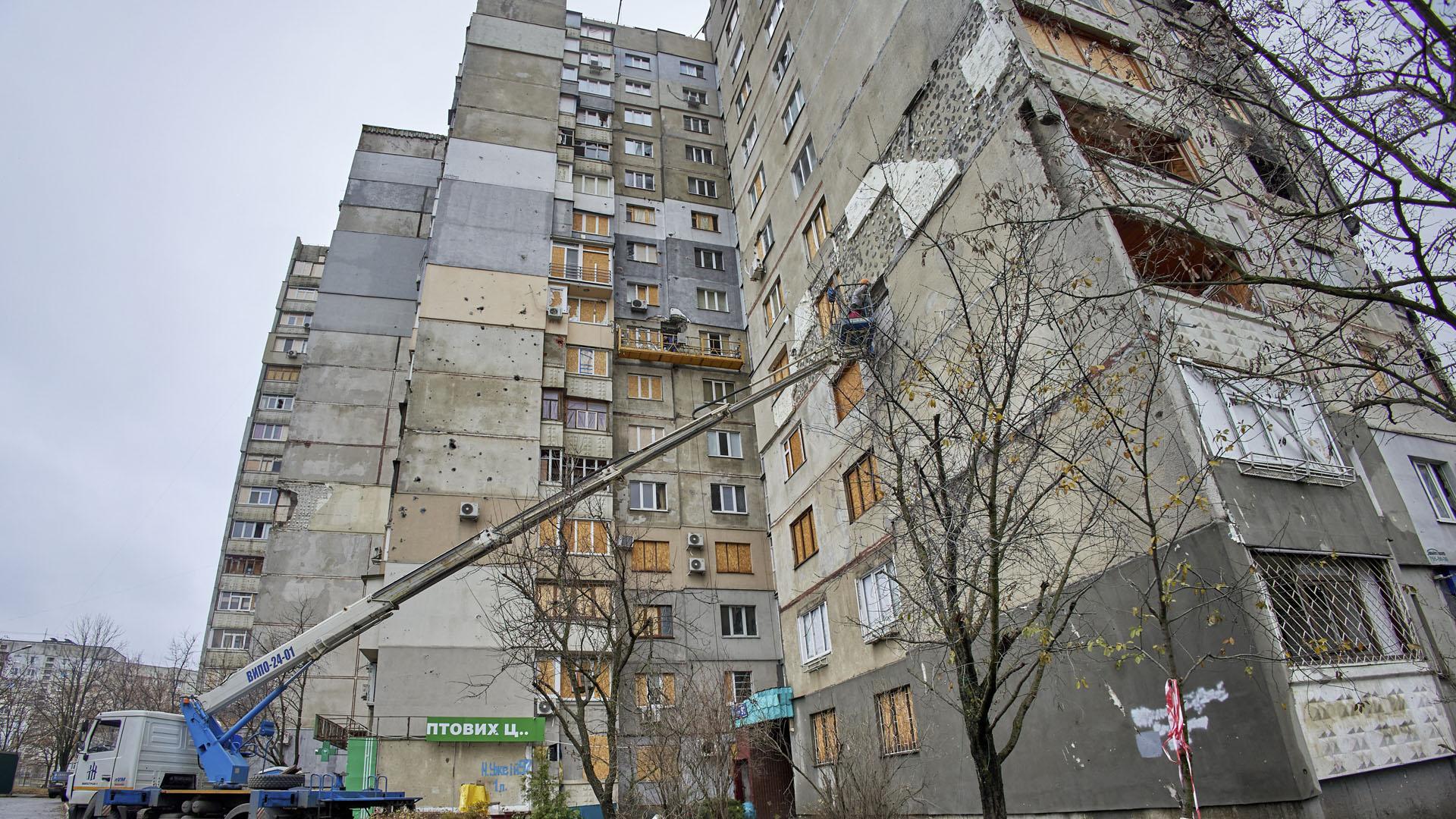 Trabajadores reparan un edificio dañado por las bombas en Járkov