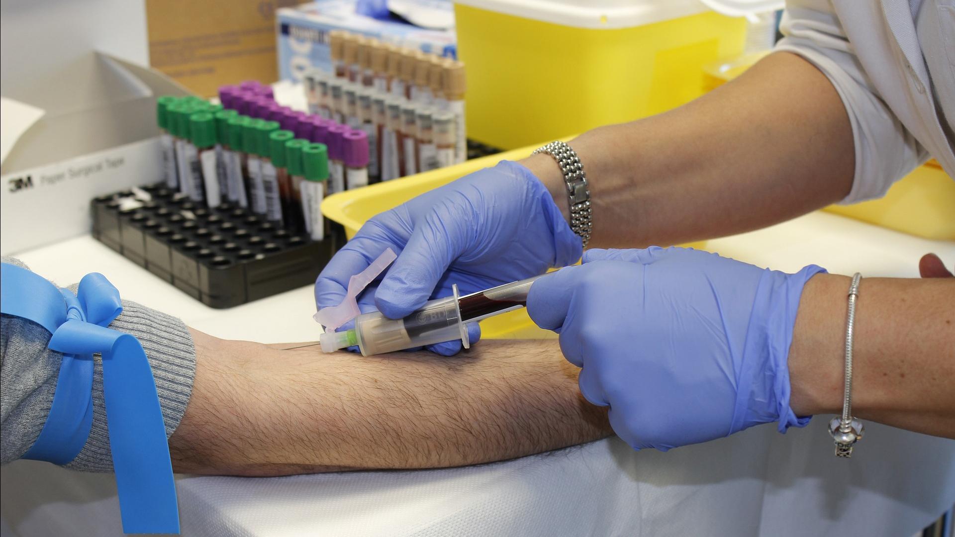 Una sanitaria saca sangre a un paciente