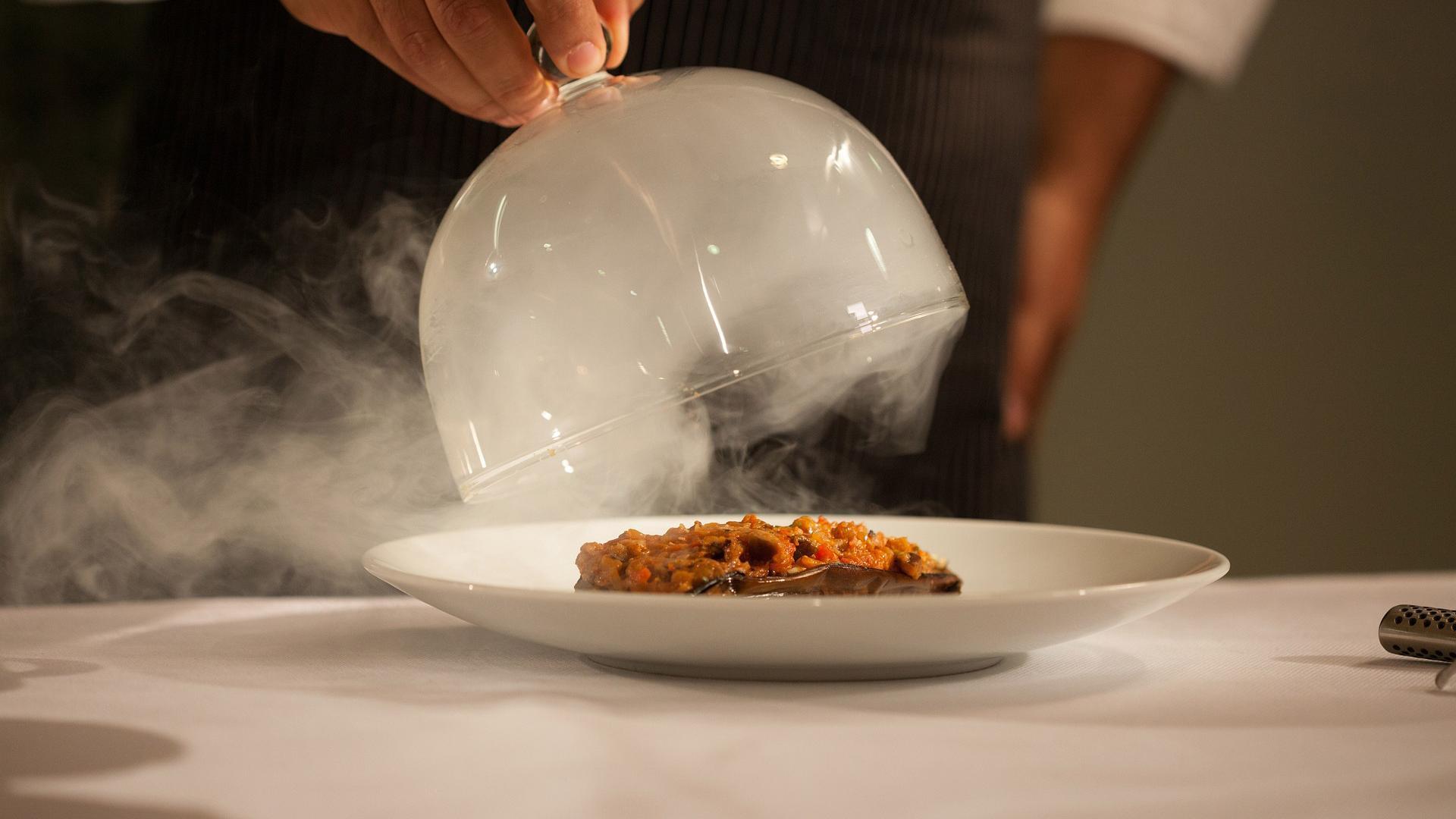 Un camarero sirve un plato en un restaurante