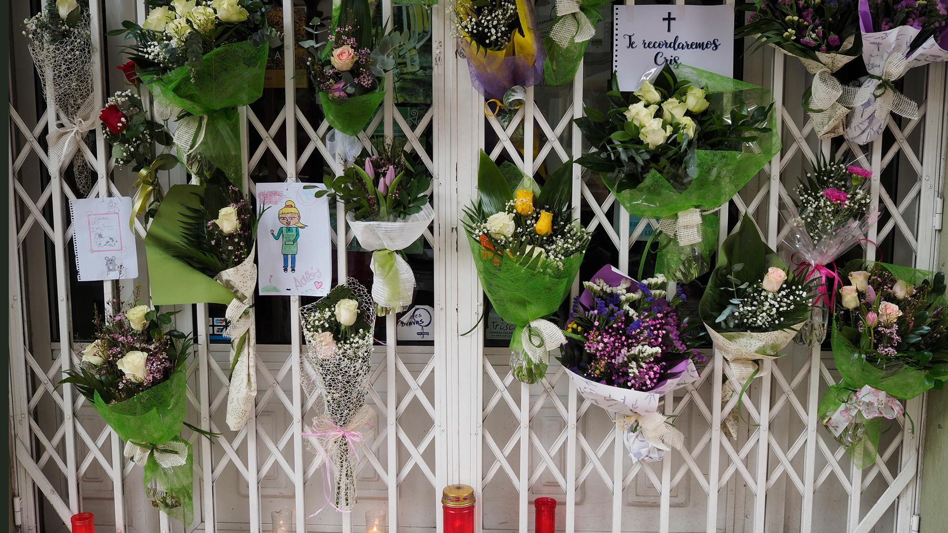 Vecinos de Lugo dejan ramos de flores, mensajes escritos y velas encendidas en la puerta de la tienda que regentaba Cristina Cabo Buján, la mujer asesinada a cuchilladas en su domicilio