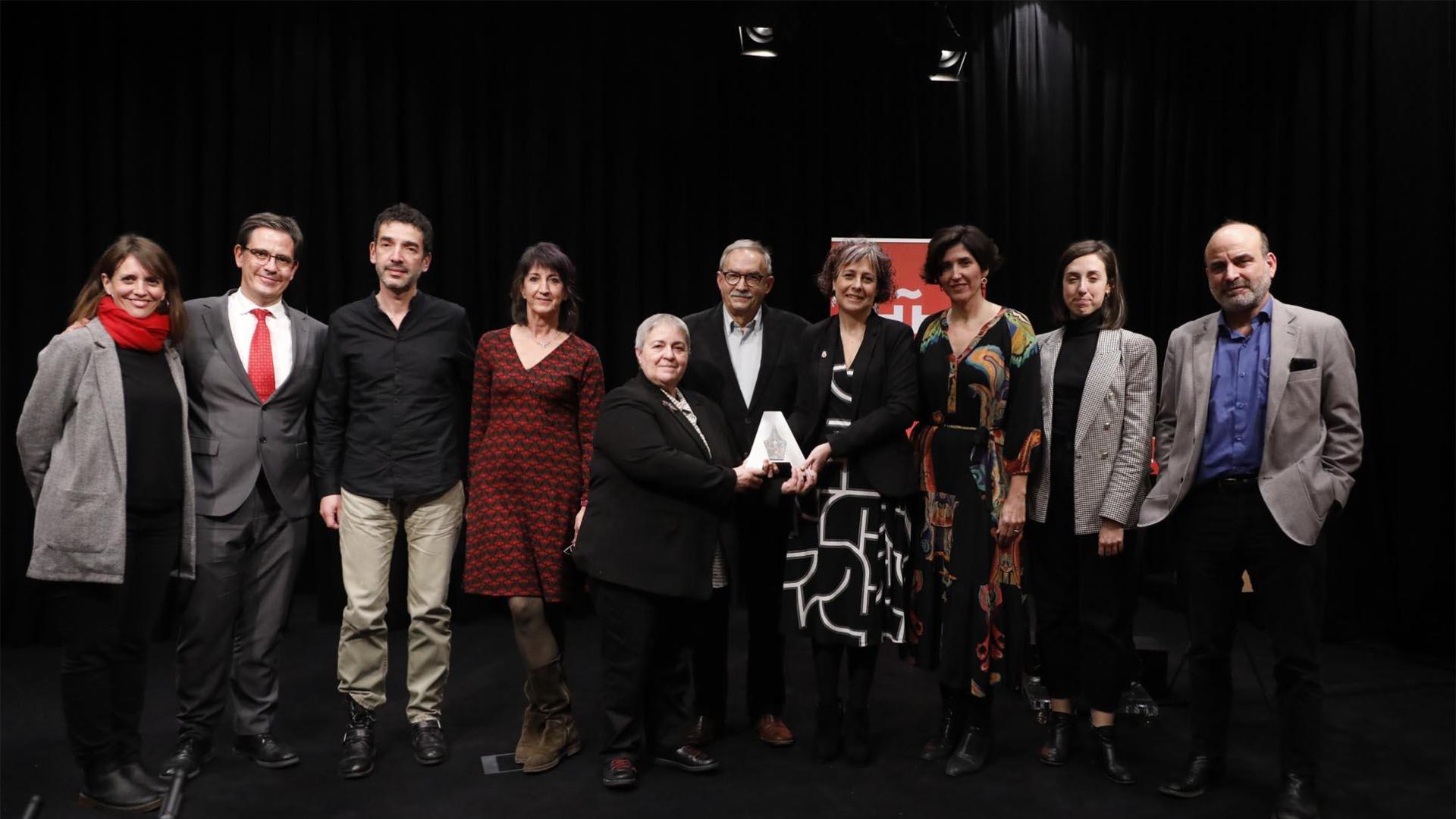 En el centro, Asunción Maestro, Miguel Rico y la consejera Esnaola, con organizadores y responsables durante la entrega del premio