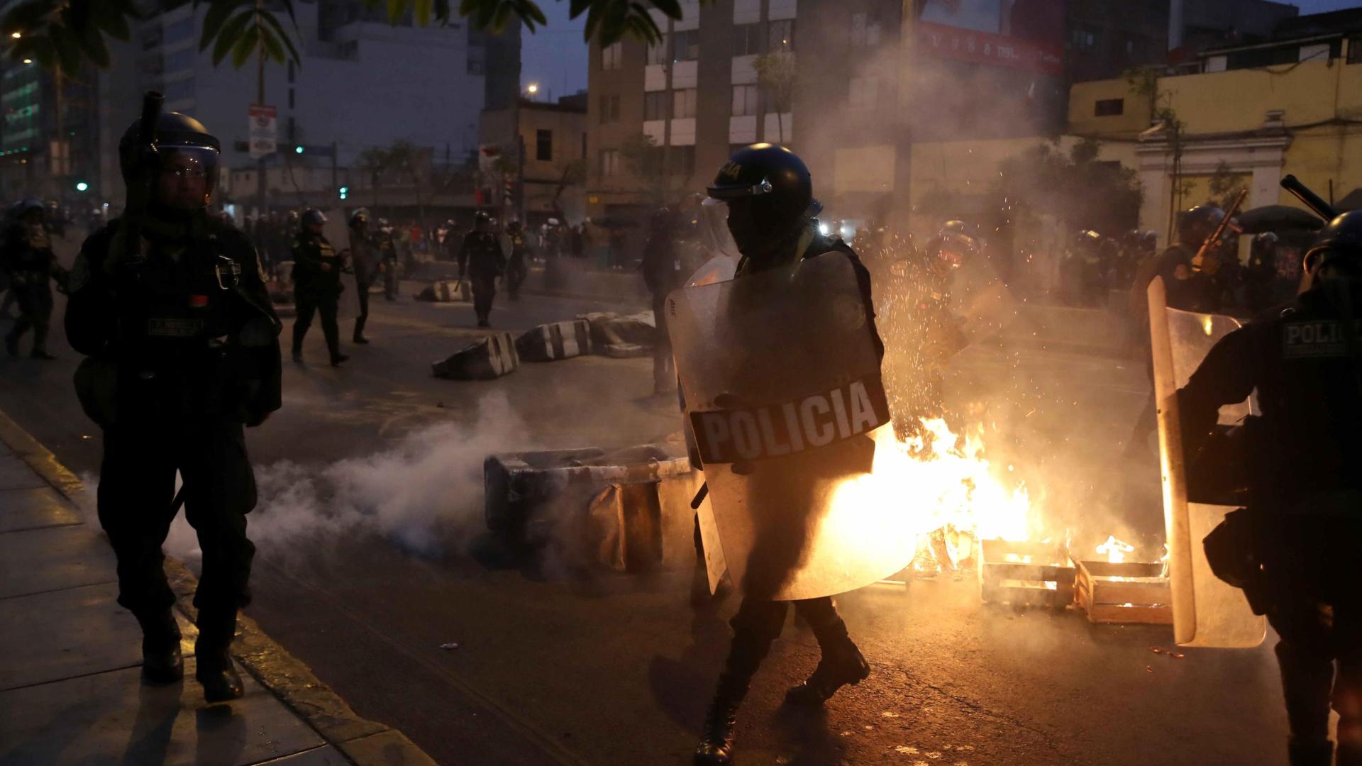 Miembros de la policía vigilan a cientos de manifestantes a favor de Pedro Castillo y en contra del Congreso que se manifiestan en las calles del centro