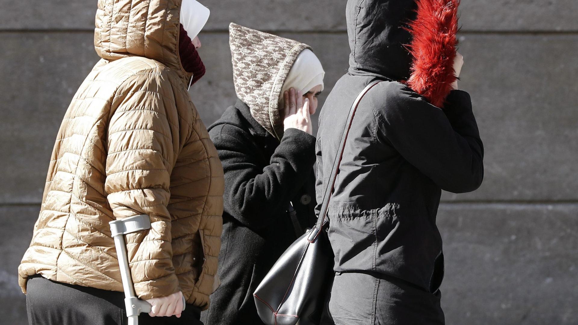 Un grupo de mujeres caminan muy protegidas del frío por una calle de Pamplona.