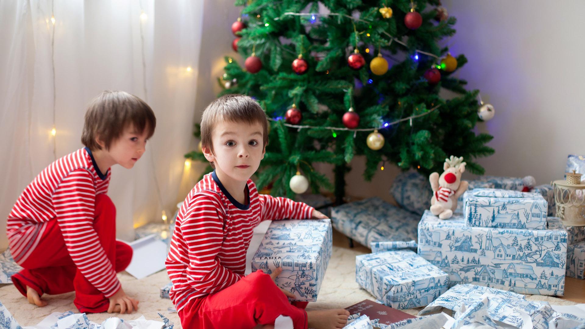 Dos niños abren sus regalos navideños