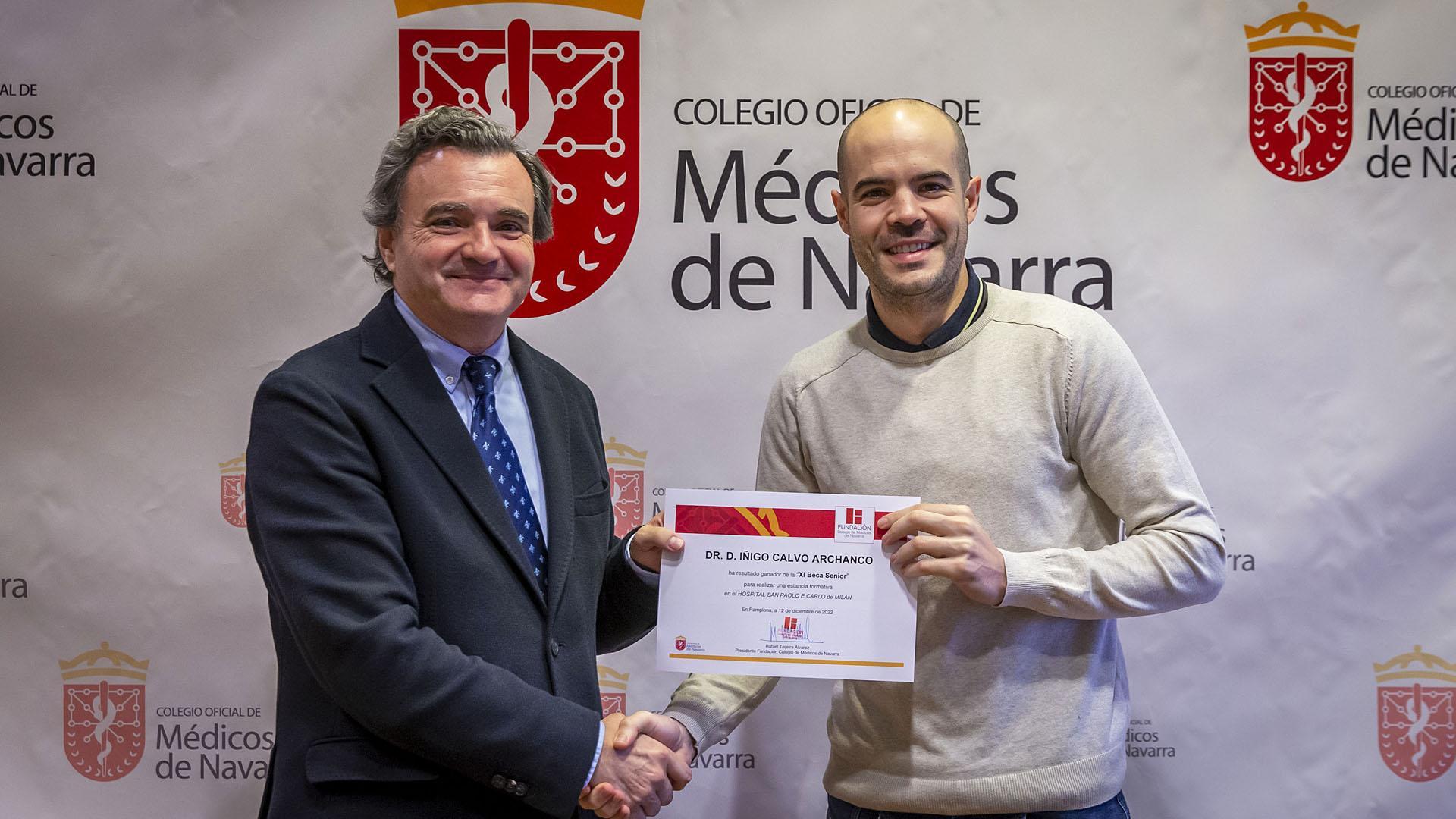 El cirujano Íñigo Calvo (derecha) recibe la beca de la mano del presidente del Colegio de Médicos de Navarra, Rafael Teijeira.