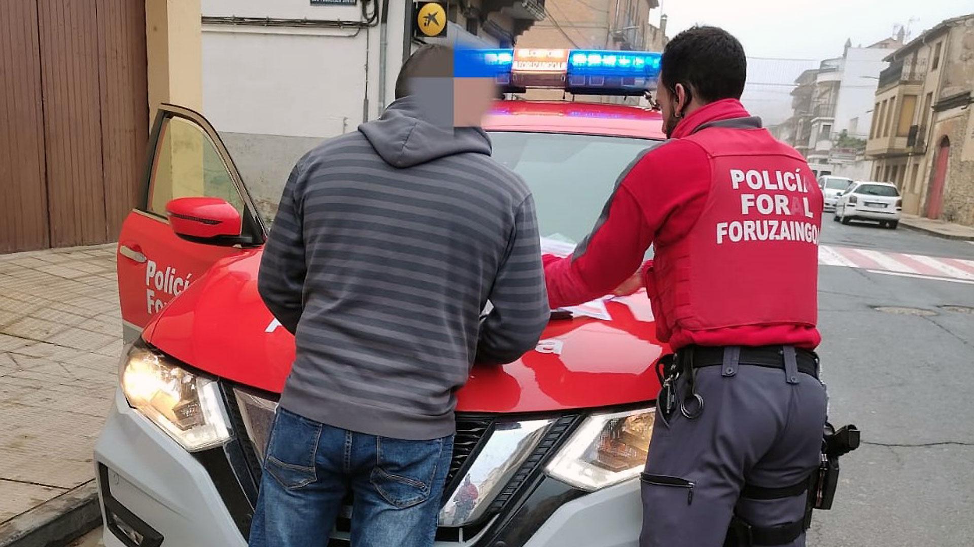 Un agente de la Policía Foral, junto al conductor que ha cometido la infracción