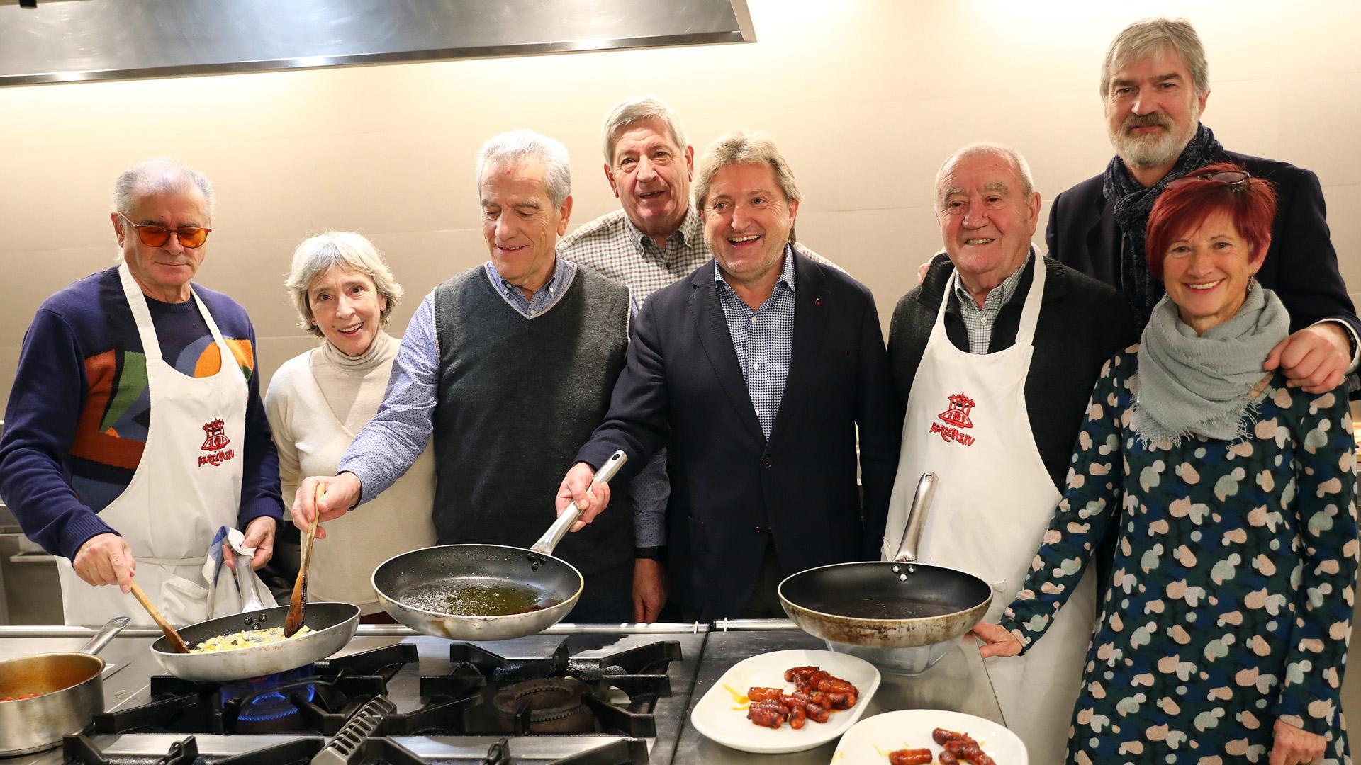 La presidenta del Teléfono de la Esperanza, Begoña Arbeloa (a la derecha), y Alfonso Echávarri, director,  con integrantes de la sociedad Gazteluleku. Con la sartén en la mano, Juan Mari idoate, del Europa.