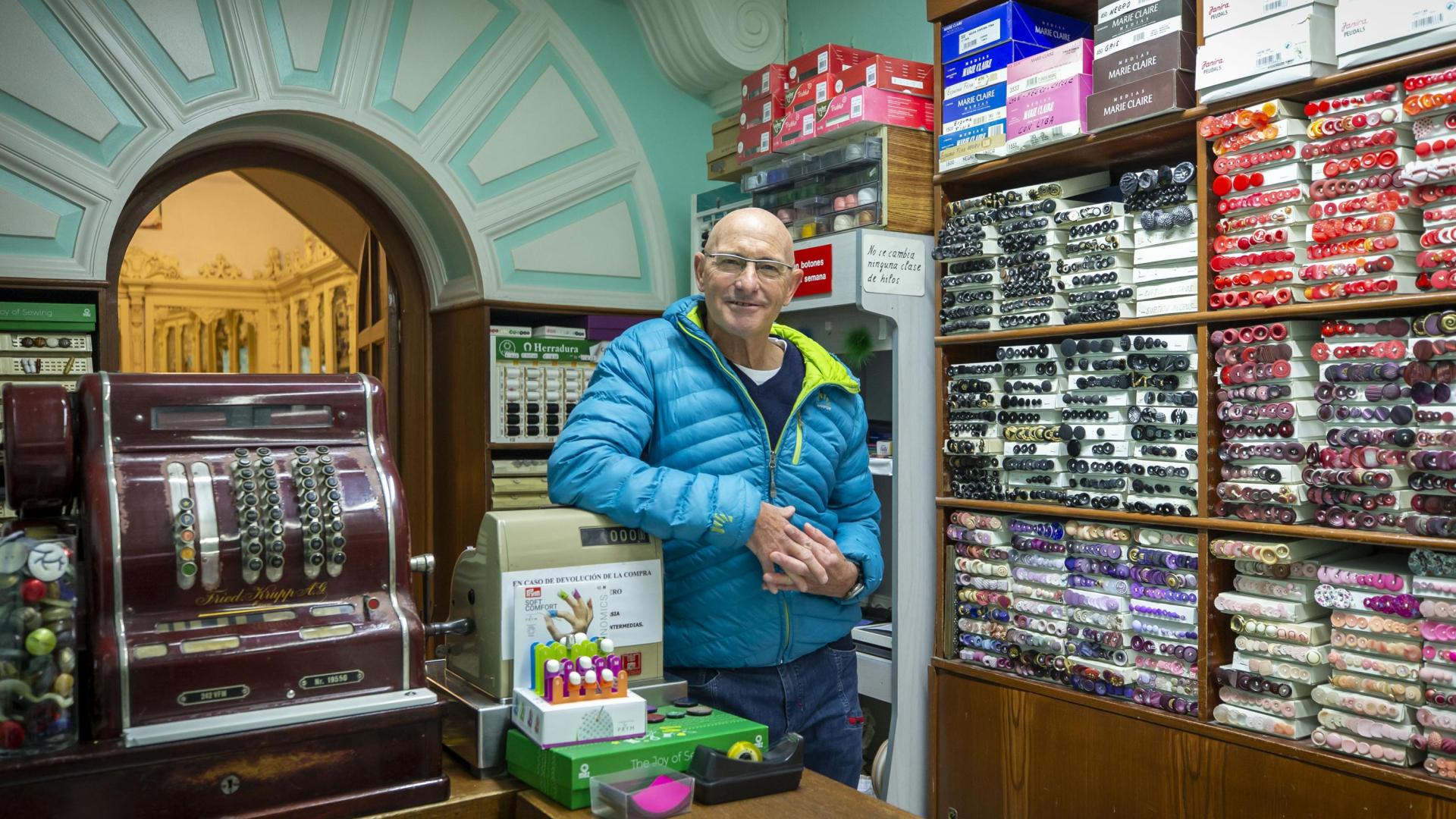 Paco Roda posa tras el mostrador de Mercería Ferrán, en la calle Mayor, un negocio que este 2022 ha cumplido un siglo y que tiene a Paqui Etayo al frente desde hace 51 años