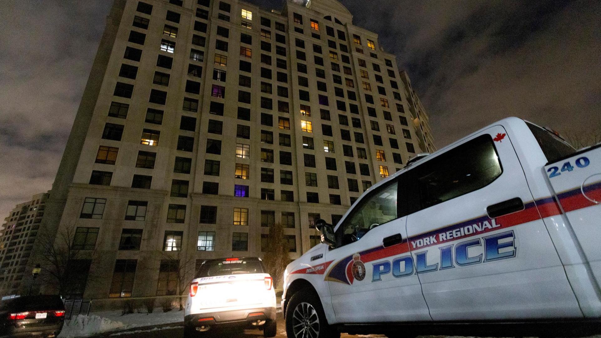 Vehículos policiales aparcados frente al edificio en el que se ha producido un tiroteo masivo en Toronto