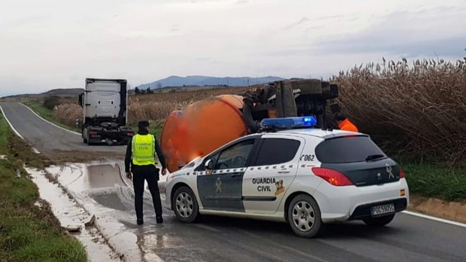Una patrulla de la Guardia Civil junto al camión volcado.