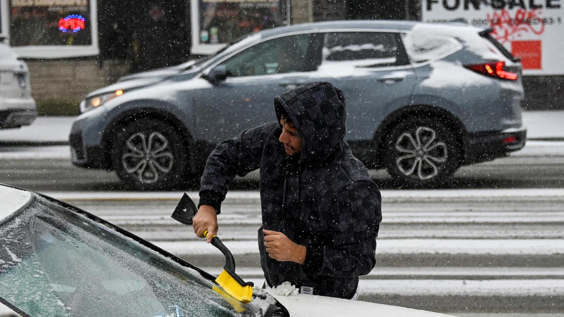 Un hombre rasca el hielo de su coche en Chicago
