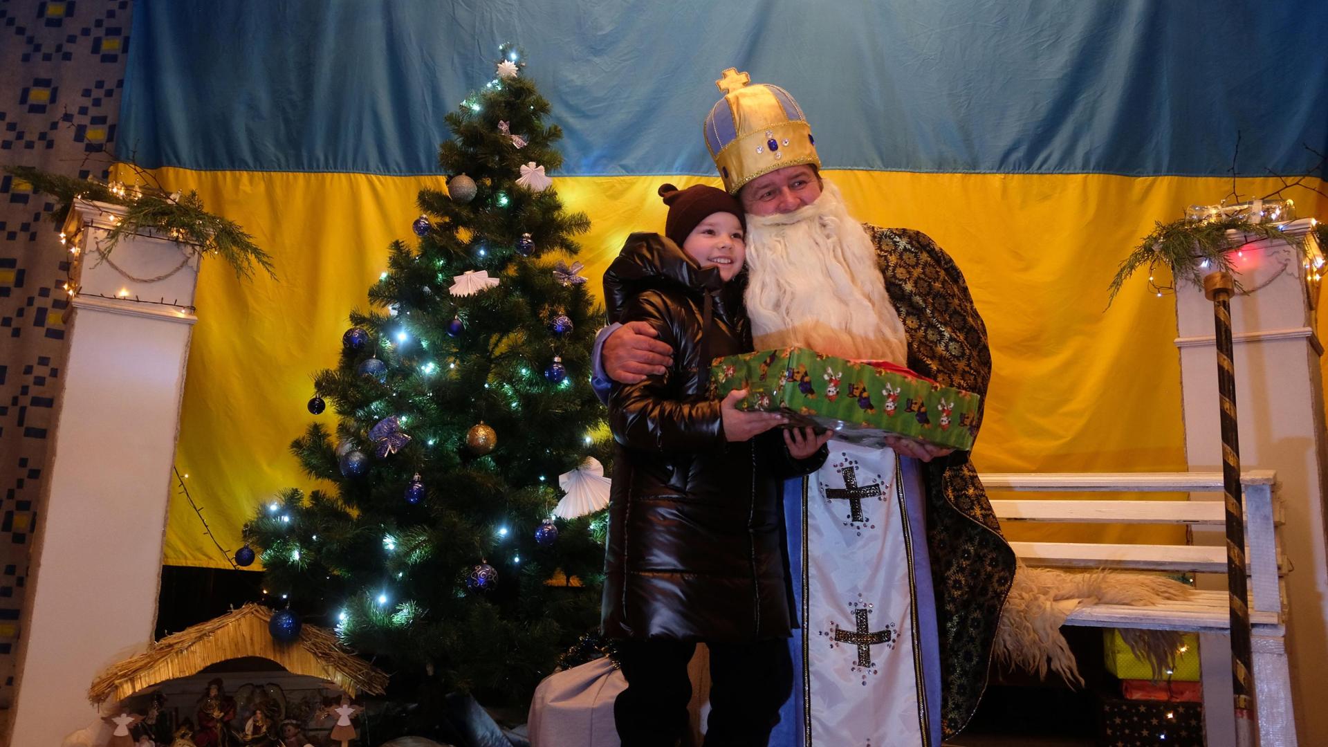 SKOLE (UCRANIA). San Nicolás entrega el regalo de Teresa Uriarte a Katerina, una niña a la que su madre tuvo que tapar los ojos bajo los bombardeos mientras huían de su pueblo hacia Skole.