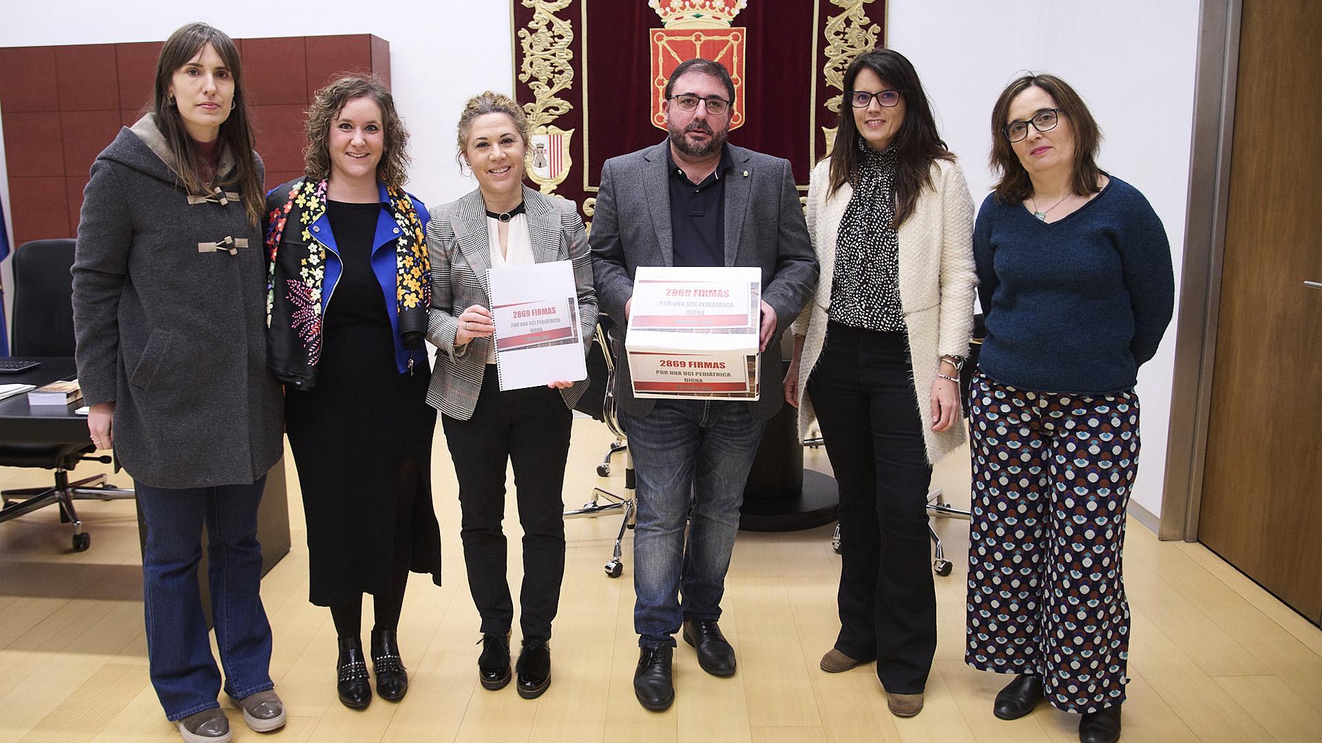 Representantes de profesionales y madres durante la visita al Parlamento de Navarra junto a su presidente, Unai Hualde.