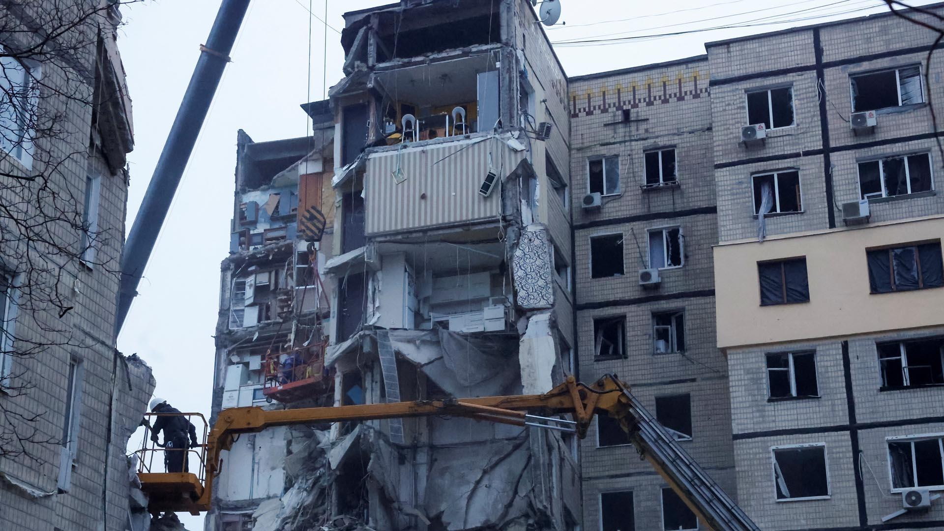 Operarios trabajan en el edificio alcanzado por el misil ruso en Dnipro