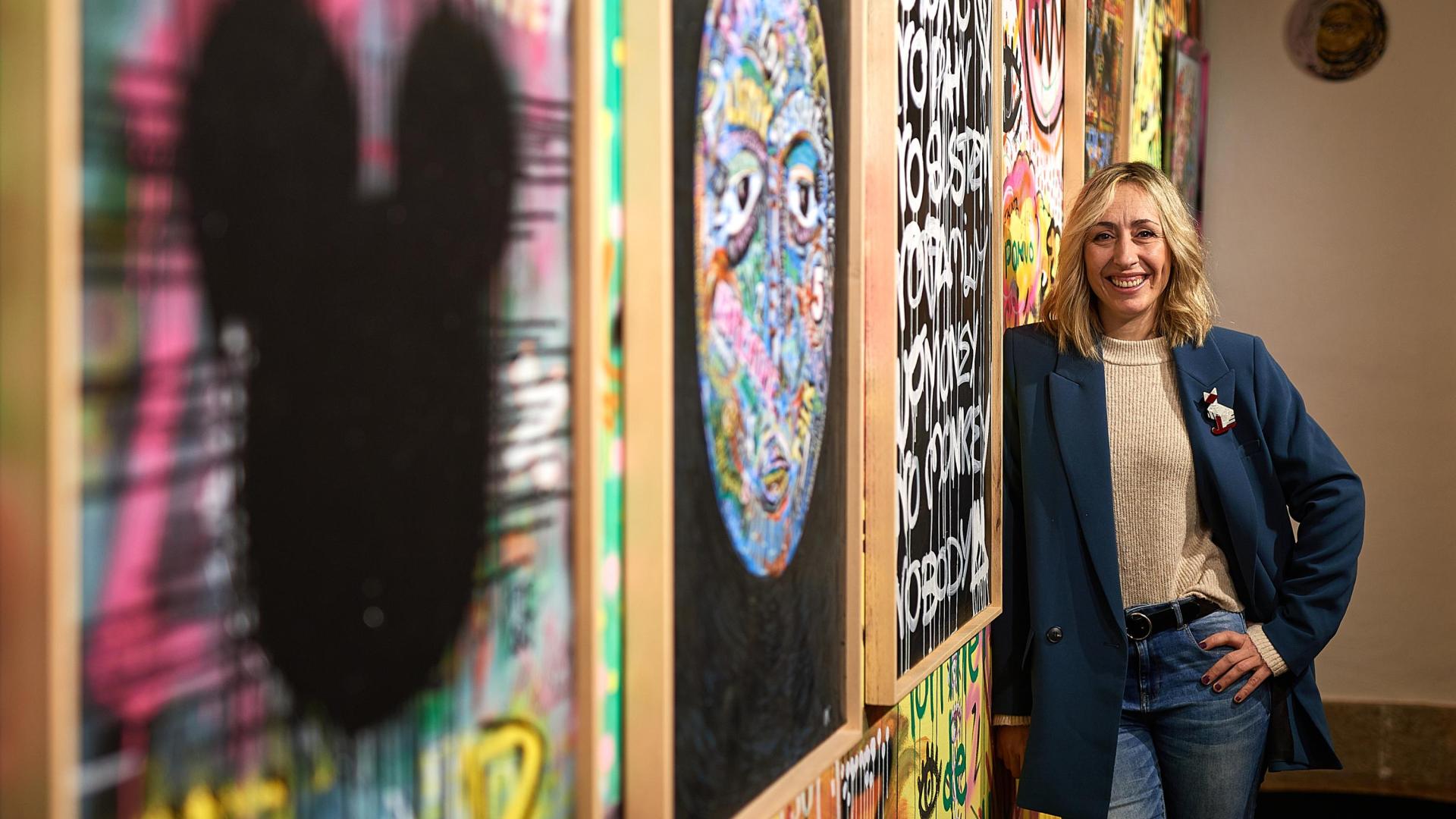La pamplonesa Cristina Navarlaz posa con el mural ‘pintado en vivo’ (‘live painting’), junto a su prima Jara Navarlaz y 50 personas anónimas.