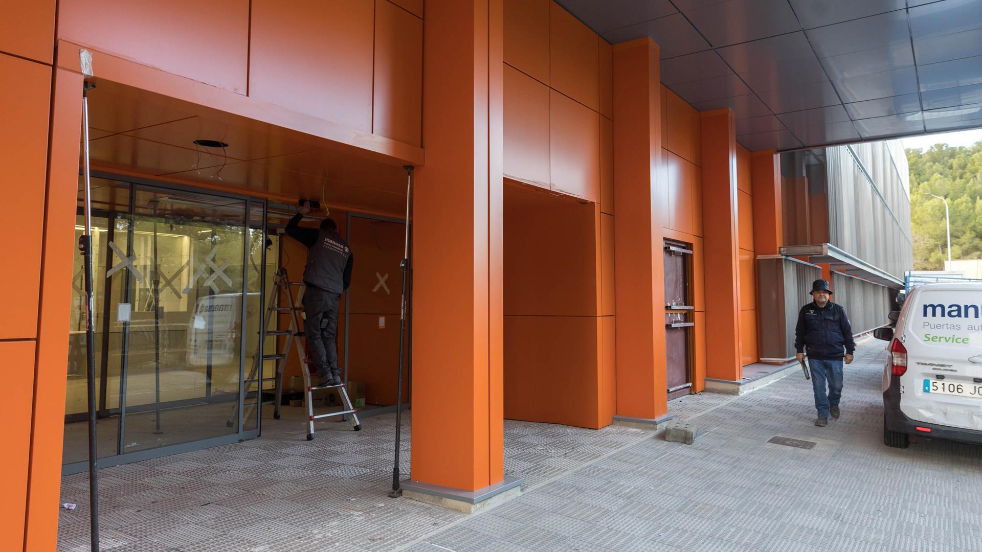 Un operario ultima trabajos en la puerta de acceso a la nueva unidad de Hemodiálisis del Reina Sofía