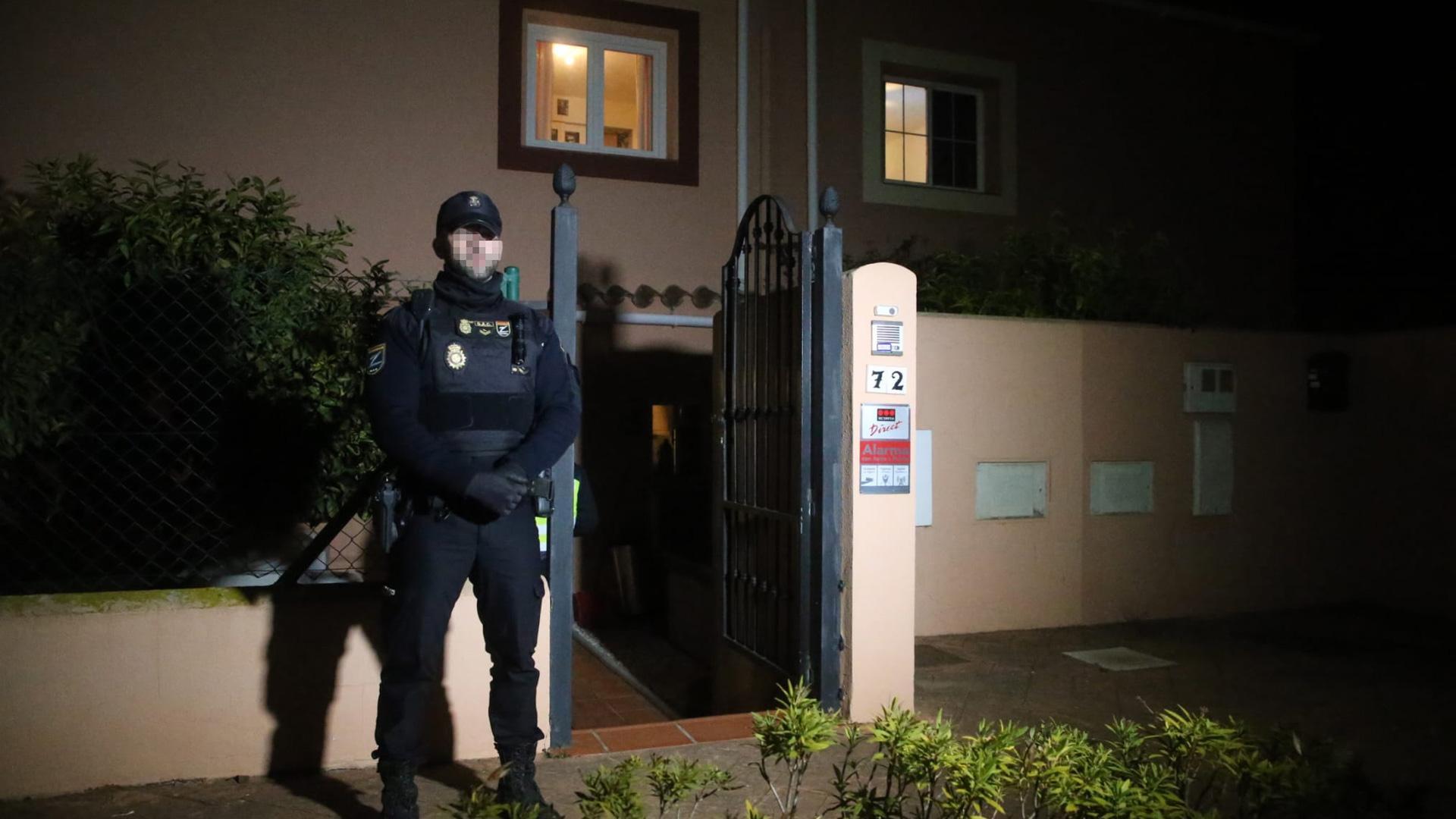 Un policía nacional custodia el domicilio en el que se han localizado los cadáveres de un hombre y una mujer muertos por disparos