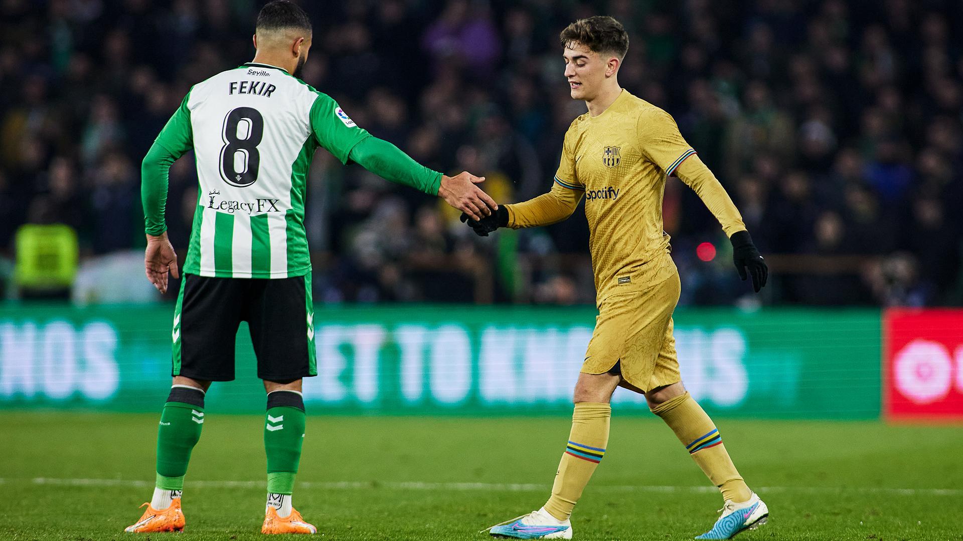 Fekir y Gavi se saludan tras una jugada del partido.