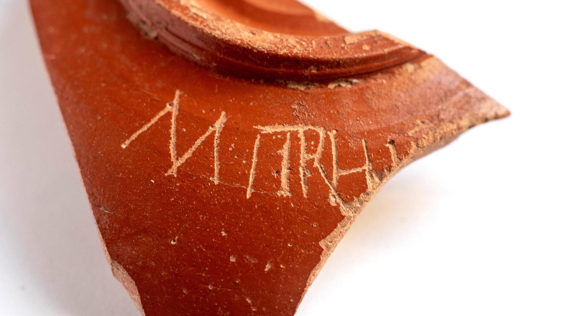 Imagen de la pieza, en la que figura la inscripción ‘Mitrh’. El fragmento pertenece a un recipiente doméstico, “una especie de bol”.