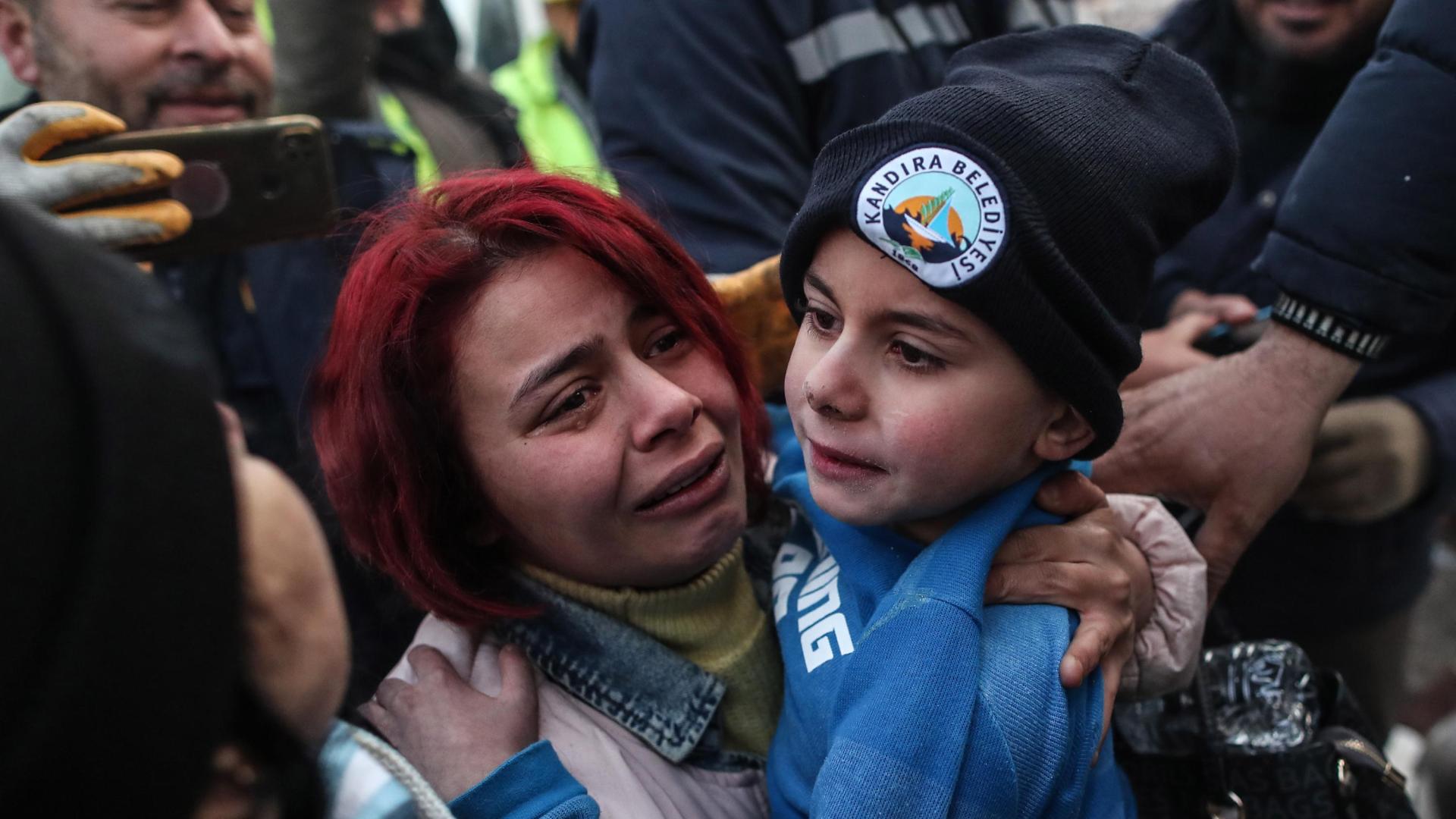 Un niño, junto a su madre, tras ser rescatado de los escombros en Turquía