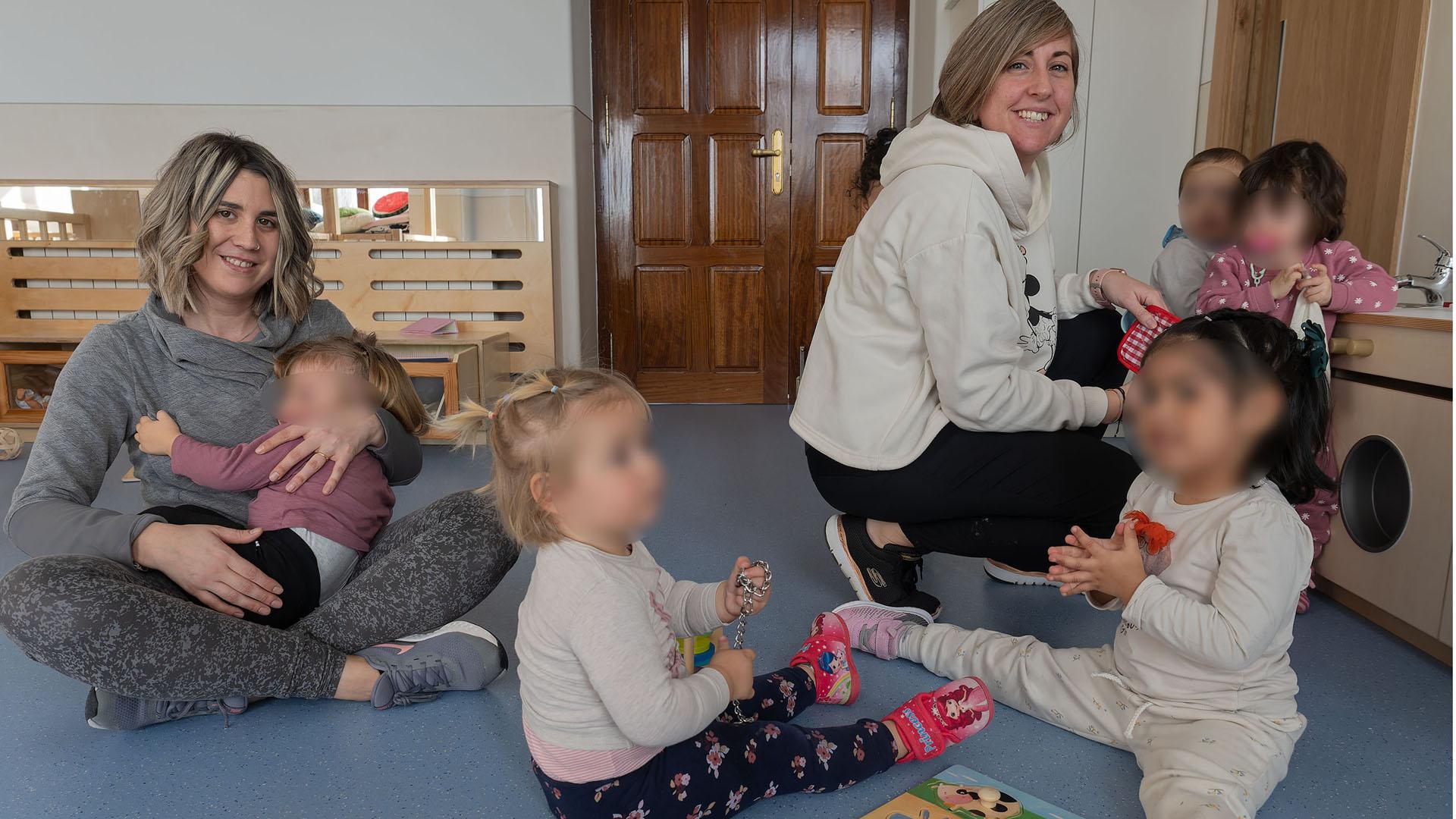 Eguiarte Ros, con una niña en brazos, educadora infantil, y la directora, Eguiarte Goñi, atienden a los niños
