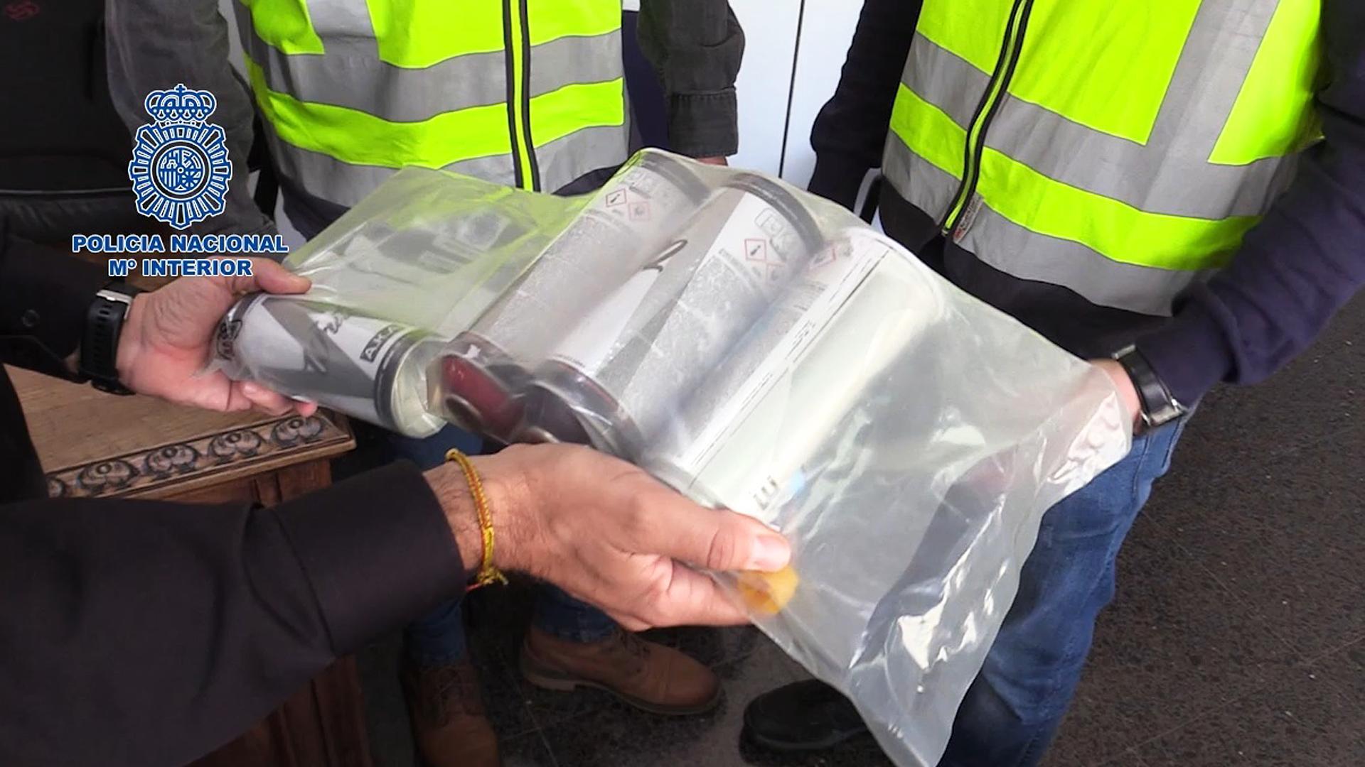 Un agente de la Policía Nacional sostiene varios botes de pintura para grafitis incautados en la operción. 

POLICÍA NACIONAL

13/02/2023