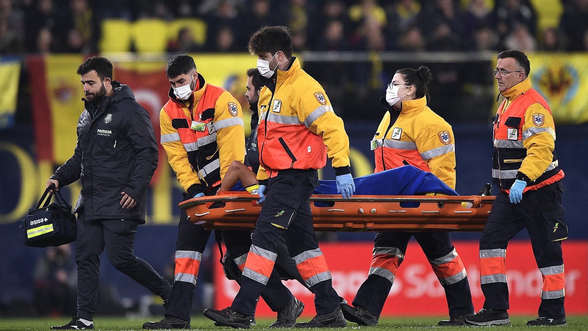 Los camilleros y un médico del Villarreal acompañan a Francis Coquelin cuando es retirado tras su lesión.