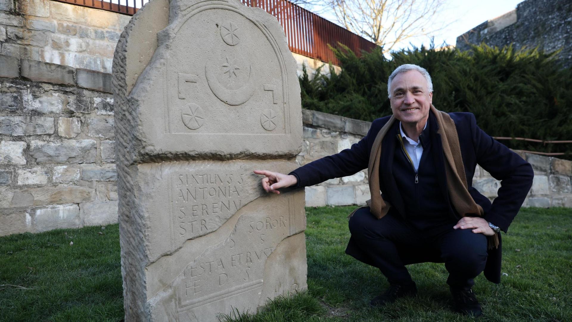 Javier Enériz, posando junto a la estela dedicada a Sixtilivs (siglos II-III), que se encuentra en la Plaza del Arzobispado de Pamplona.
