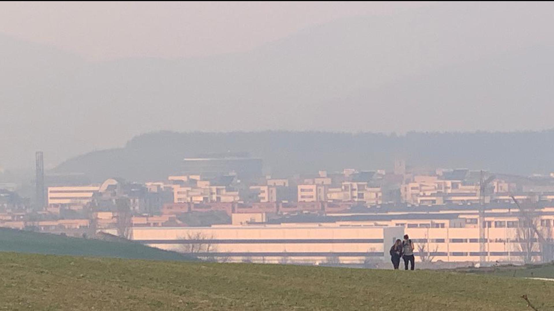 Estampa de la ciudad de Pamplona desde las afueras, velada por un ligero humo