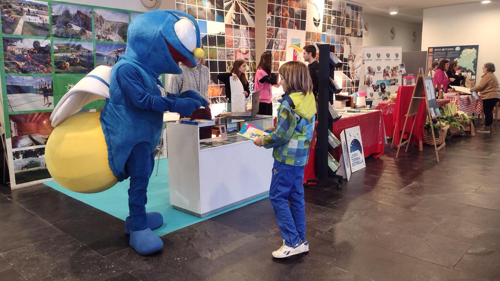 La mascota de Campings Navarra, Argi, en un expositor de Navartur