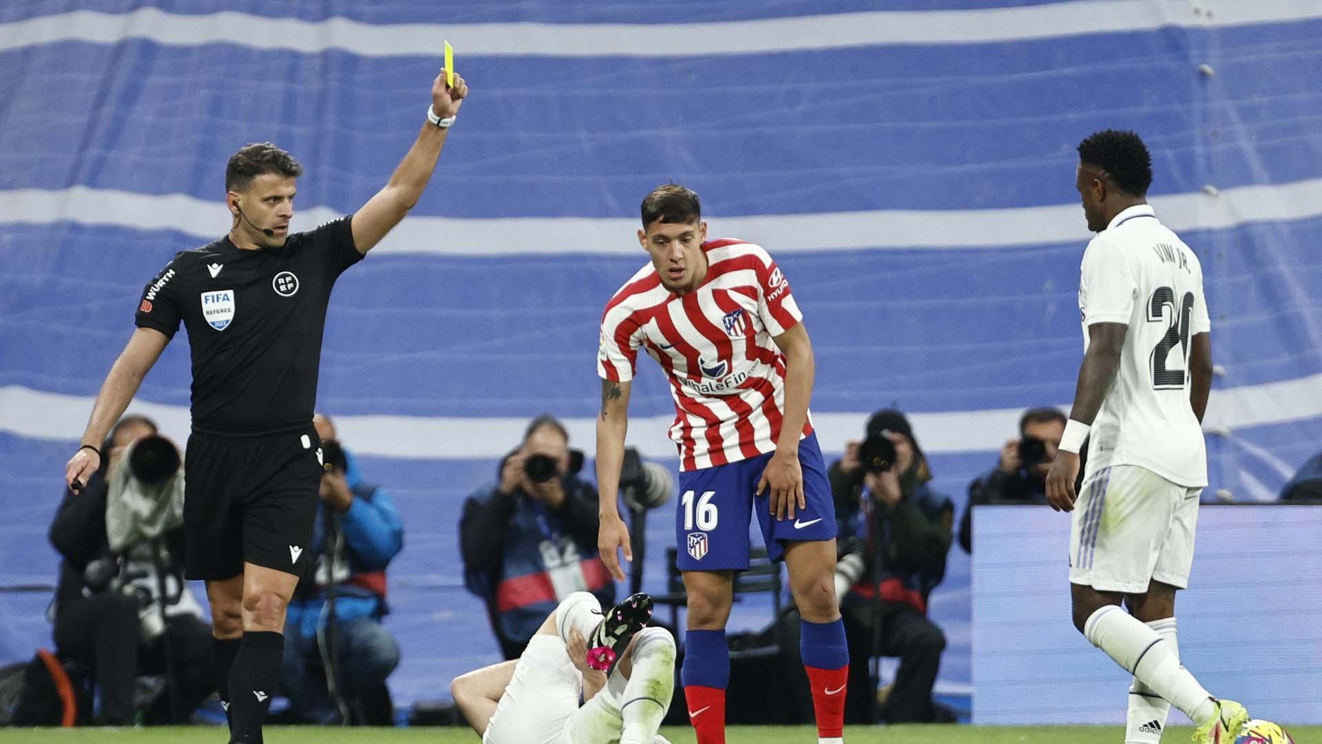 Gil Manzano muestra tarjeta amarilla al argentino Nahuel Molina (Atlético de Madrid) en el derbi ante el Real Madrid