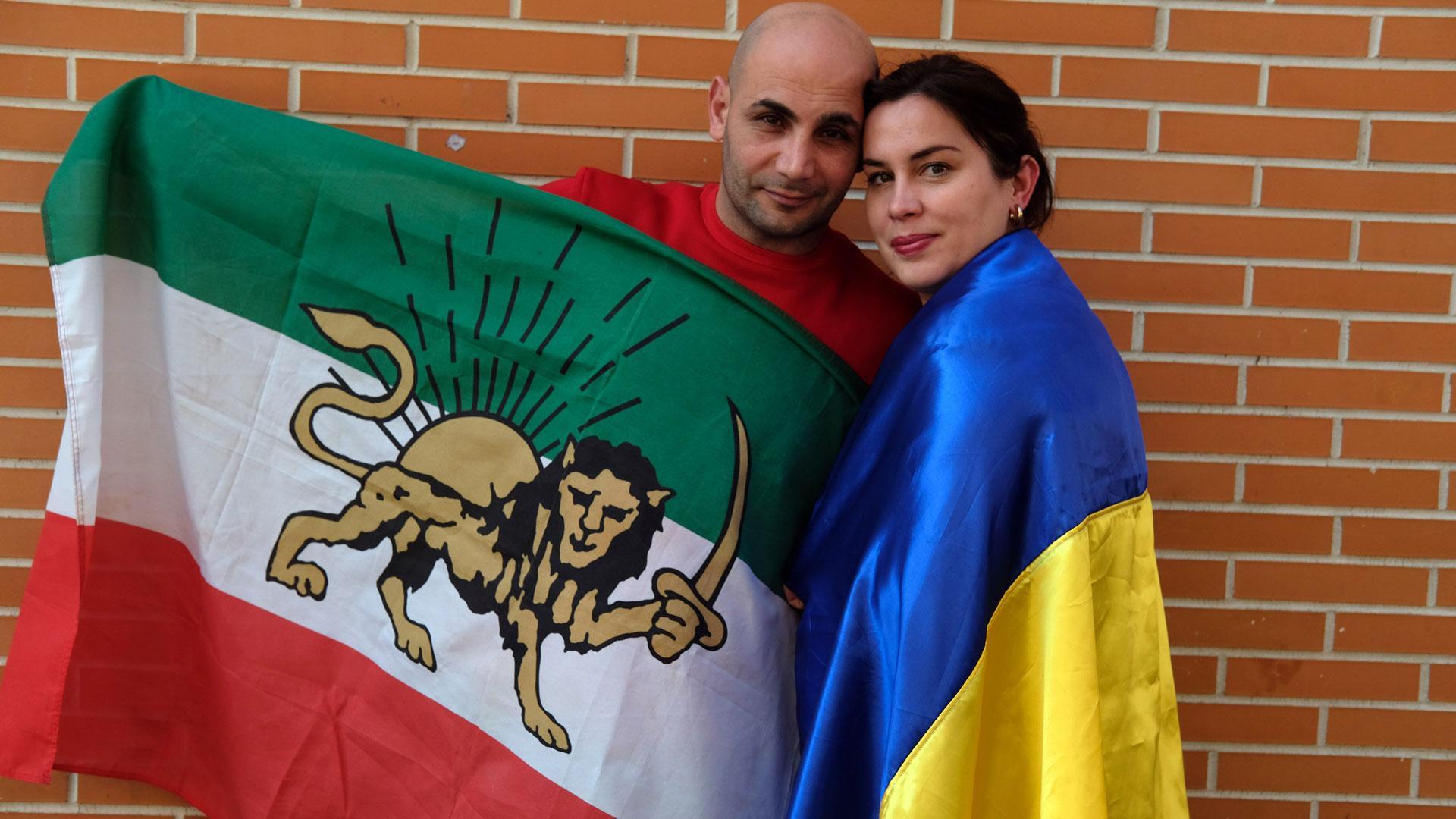 Elena y Sami, con las banderas de sus países, Ucraniana e Irán, en el barrio pamplonés de la Rochapea