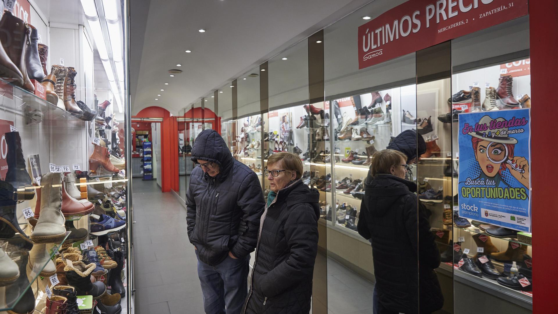 Dos personas observan las ofertas de una zapatería en el Casco Antiguo pamplonés