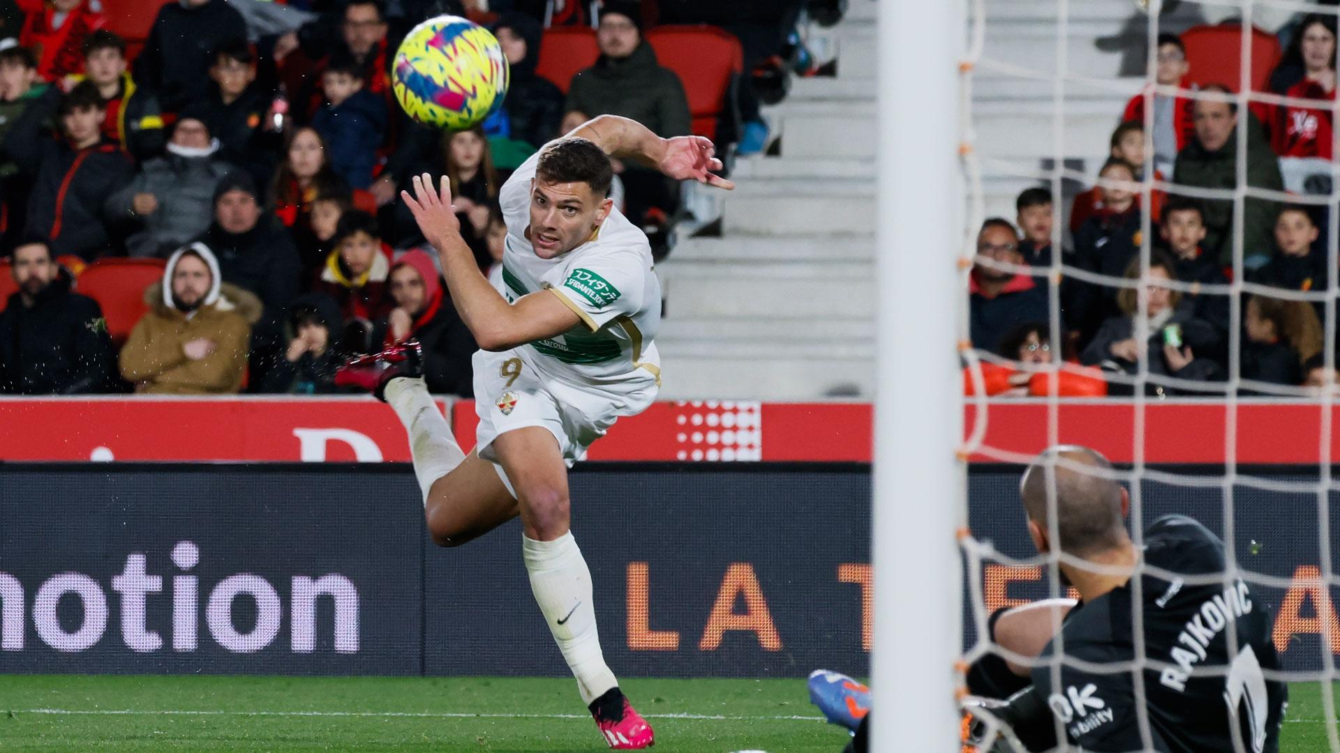 El delantero del Elche Lucas Boyé trata de superar al portero Predrag Rajkovic, del Mallorca