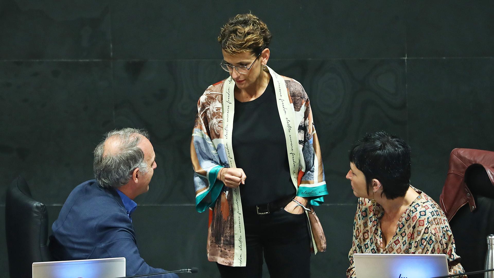 La presidenta de Navarra y secretaria general del PSN, María Chivite, habla con los parlamentarios de EH Bildu, Aldolfo Araiz y Laura Aznal,  antes del inicio de un pleno en el Parlamento.