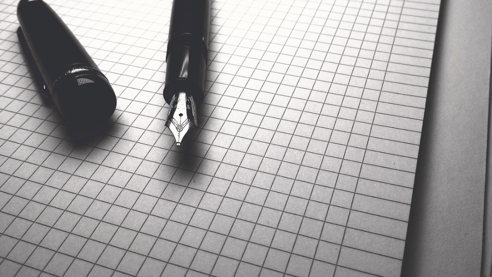 Imagen de archivo de una pluma y un papel
