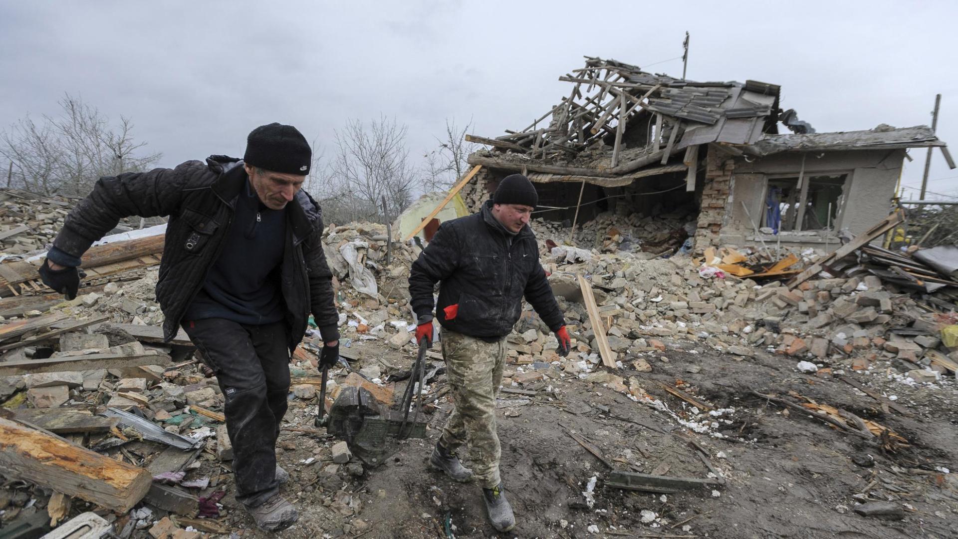 Los lugareños rescatan artículos después de que dos cohetes impactaran en edificios privados en el distrito de Zolochiv, cerca de la ciudad de Lviv, en el oeste de Ucrania