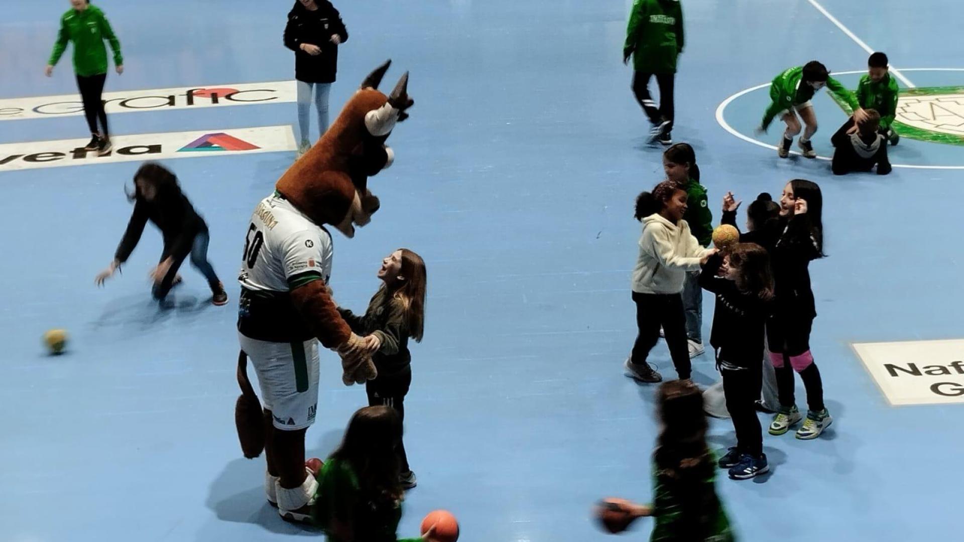 Gigi, mascota del Helvetia Anaitasuna, jugando en el descanso con algunos de los niños que saltaron a la pista