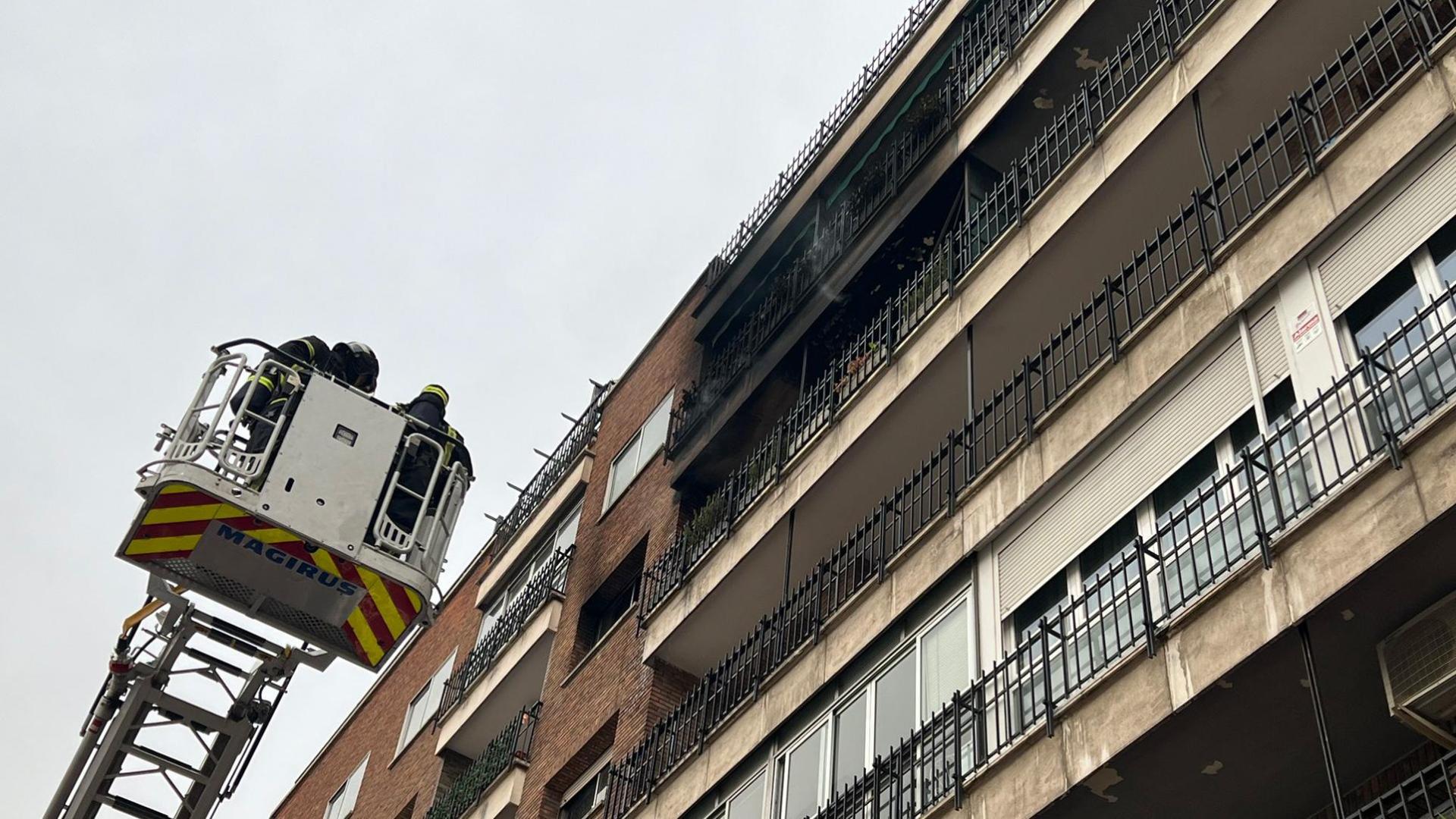 Bomberos frente a la fachada incendiada