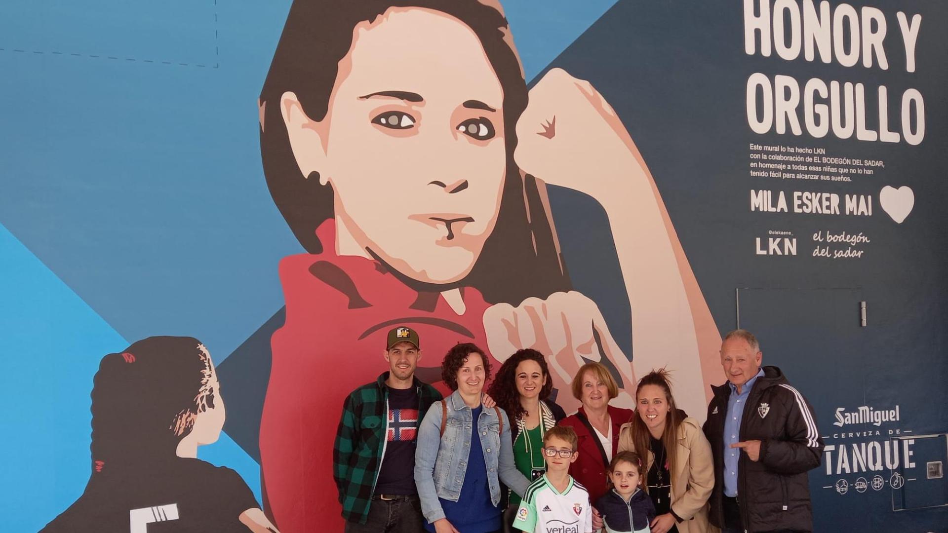 Mai Garde posa junto a su familia delante del mural
