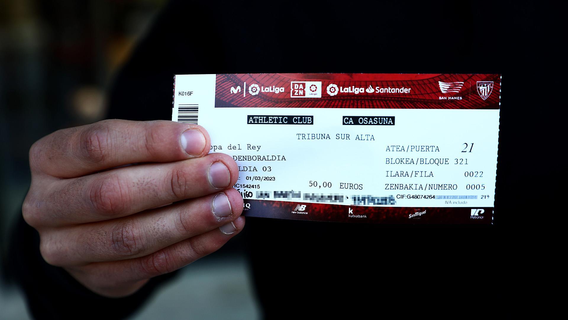 Uno de los aficionados sujeta la entrada para el Athletic-Osasuna de la vuelta de la semifinal de la Copa del Rey.