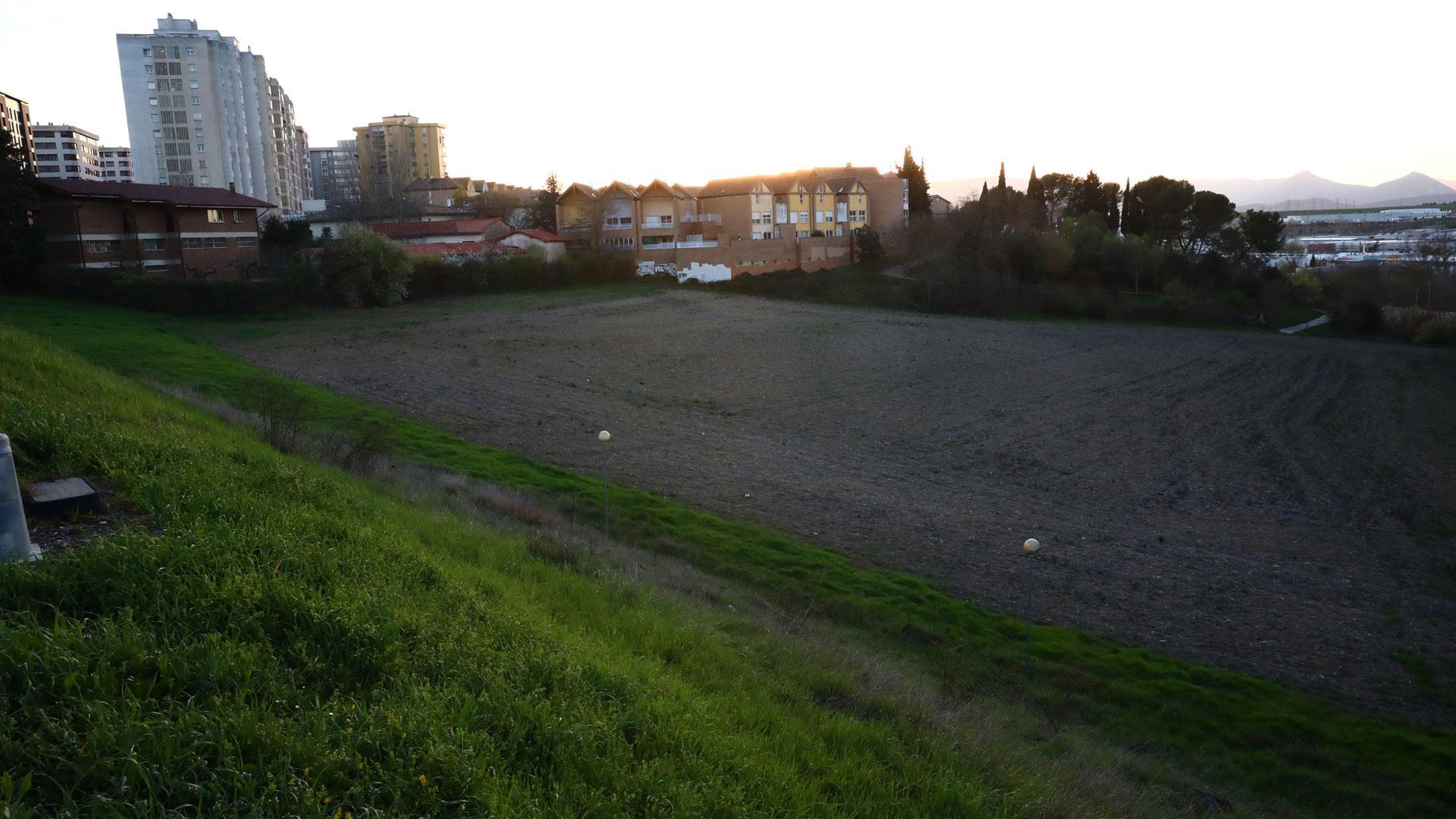 Vista de los terrenos destinados a vivienda en la nueva urbanización. Al fondo, el Pueblo Viejo