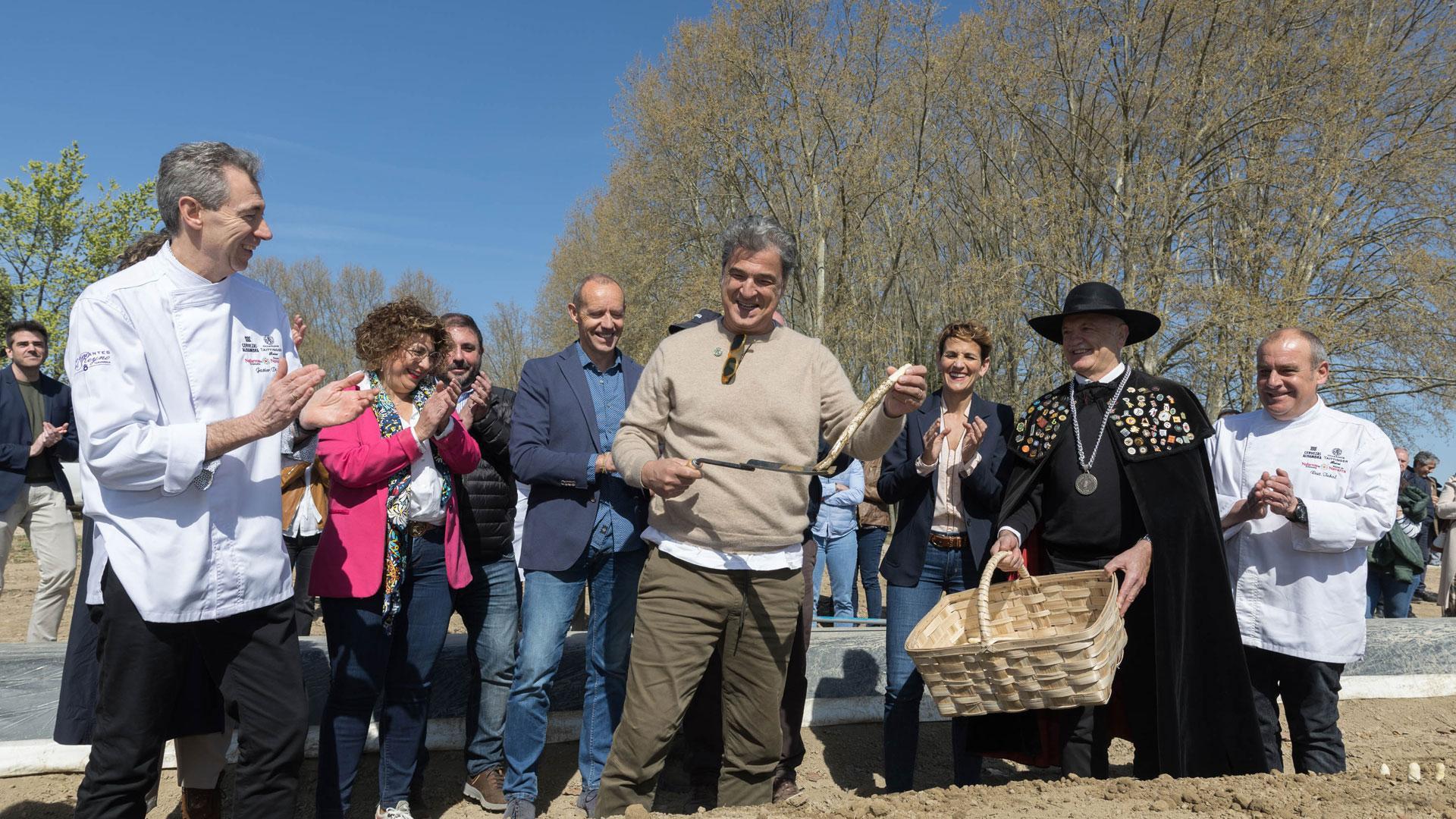 PRIMER ESPÁRRAGO El chef Carles Abellán muestra el espárrago que recogió ayer en la finca de Alfredo Rubal, de Villafranca. A su lado, de izda. a dcha.: Javier Díaz (Restaurante Alhambra), Mª Carmen Segura (alcaldesa de Villafranca), Unai Hualde (presidente Parlamento foral), Marcelino Etayo (IGP Espárrago de Navarra), María Chivite (presidenta Gobierno de Navarra), Enrique Sánchez (Cofradía Espárrago de Navarra) y Nicolás Ramírez (Restaurante Tubal)