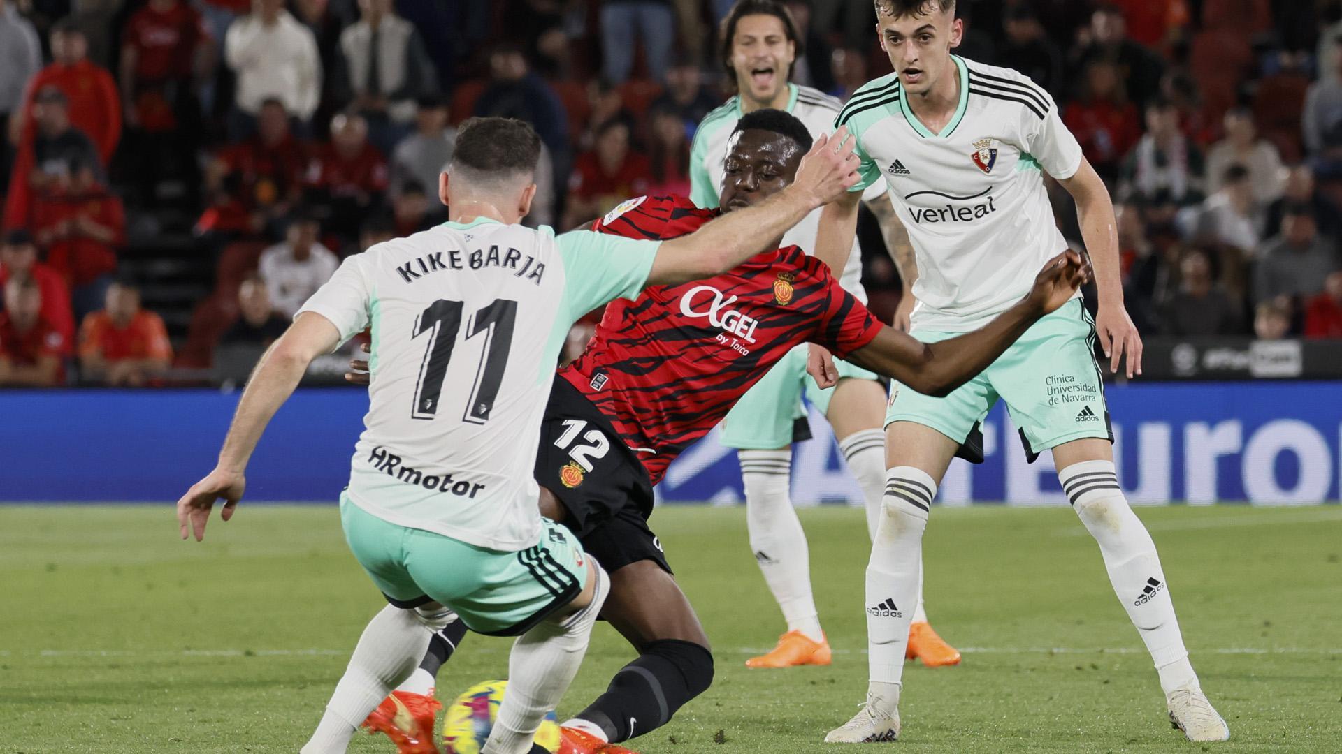 Kike Barja trata de impedir que Baba se lleve el balón ante la mirada de Aimar Oroz