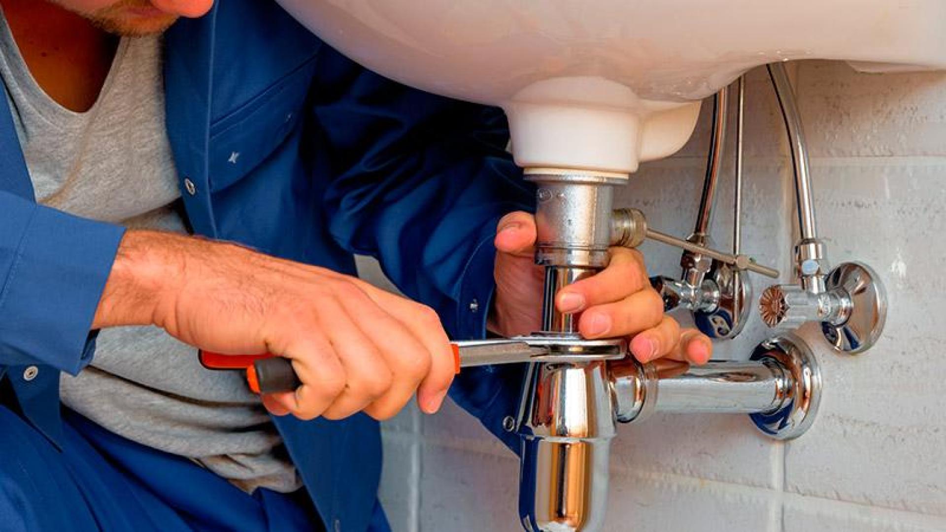 Un fontanero realiza una reparación en un lavabo