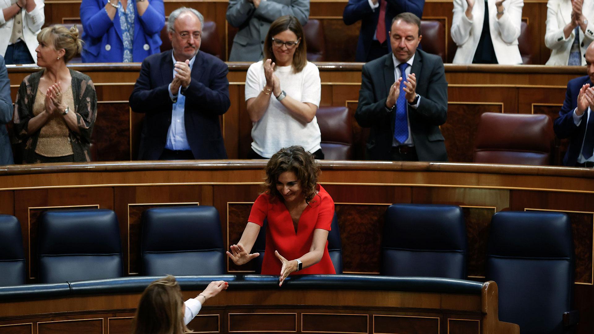 La ministra de Transportes, Raquel Sánchez (de espaldas), saluda a la ministra de Hacienda, María Jesús Montero (c), tras su intervención en el pleno celebrado, este jueves, en el Congreso de los Diputados en Madrid