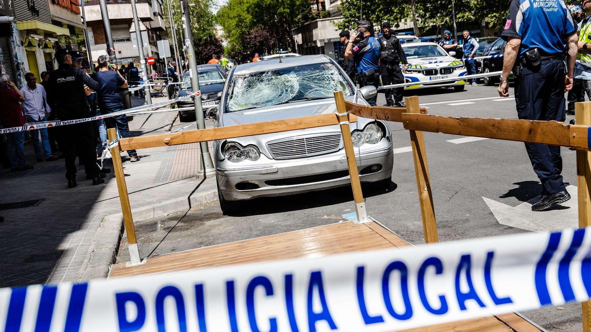 Agentes de la Policía Nacional custodian el coche con el que han sido atropelladas varias personas en el Paseo de Extremadura