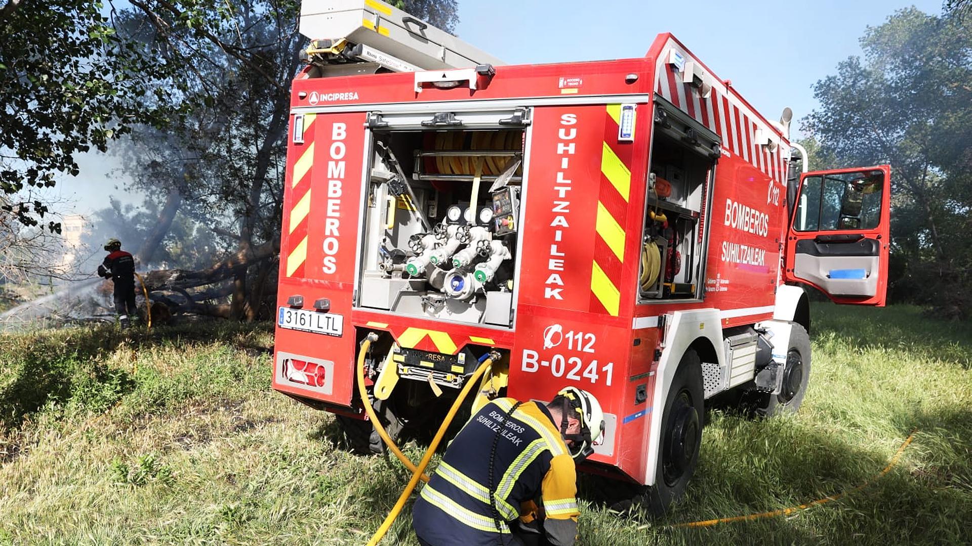 Bomberos de Navarra y agentes de la Policía Municipal de Tudela trabajan en la extinción del fuego declarado en la desembocadura del río Mediavilla