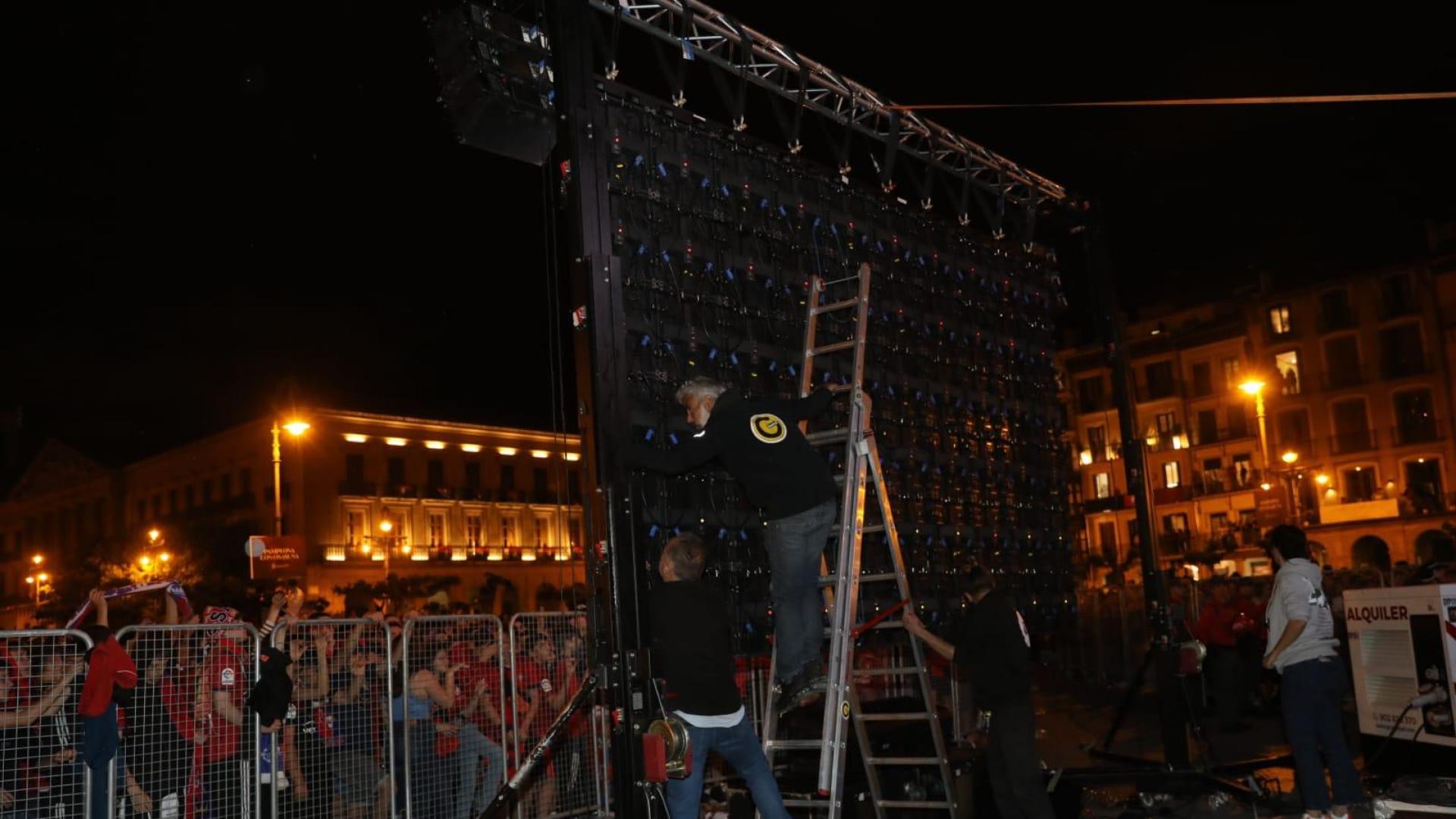 Técnicos trabajando en la pantalla que se ha caído a causa del viento en la plaza del Castillo